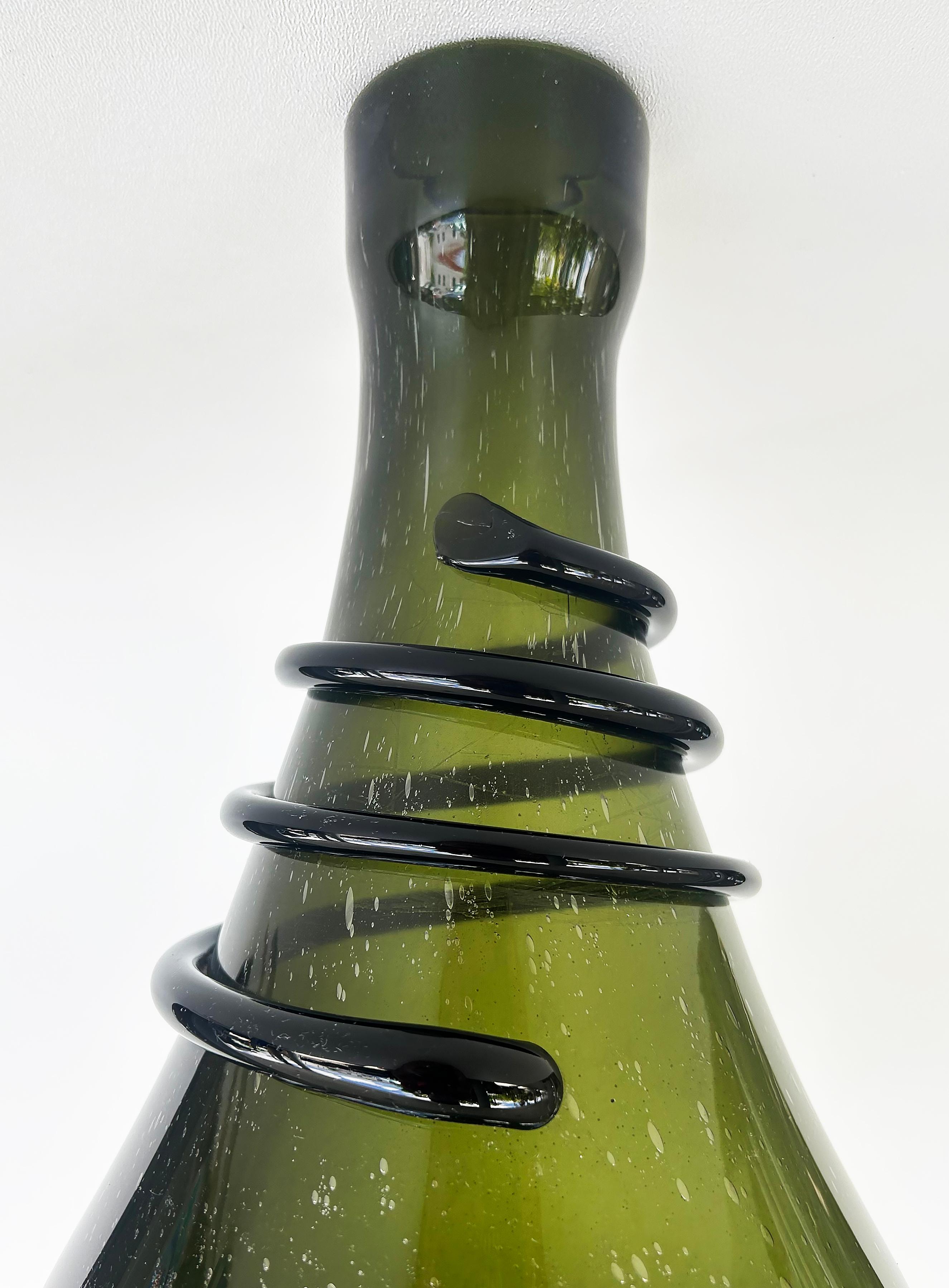 Large Antique Hand-blown Glass Bocksbeutel Wine Bottle, Coil Grip from Persia

Offered for sale is a 19th century antique olive green German Bocksbeutel wine bottle that was probably originally blown in Peria. The bottle has air bubbles from the