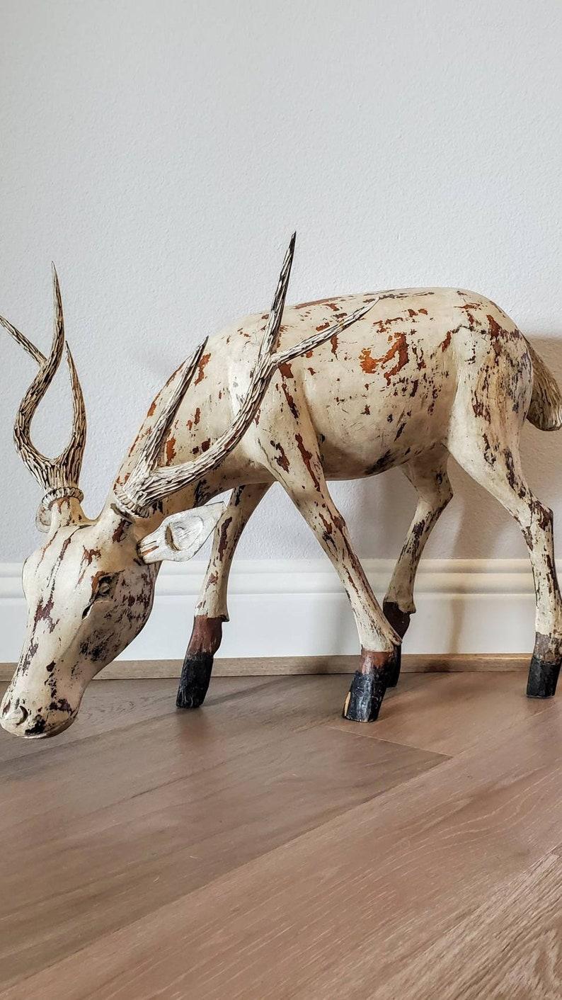 A charming and whimsical vintage hand carved stag sculpture in wood, with original distressed painted white finish, dating to the early 20th century. Exceptionally carved and sculpted from a single log, the solid wooden sculptural figure having no