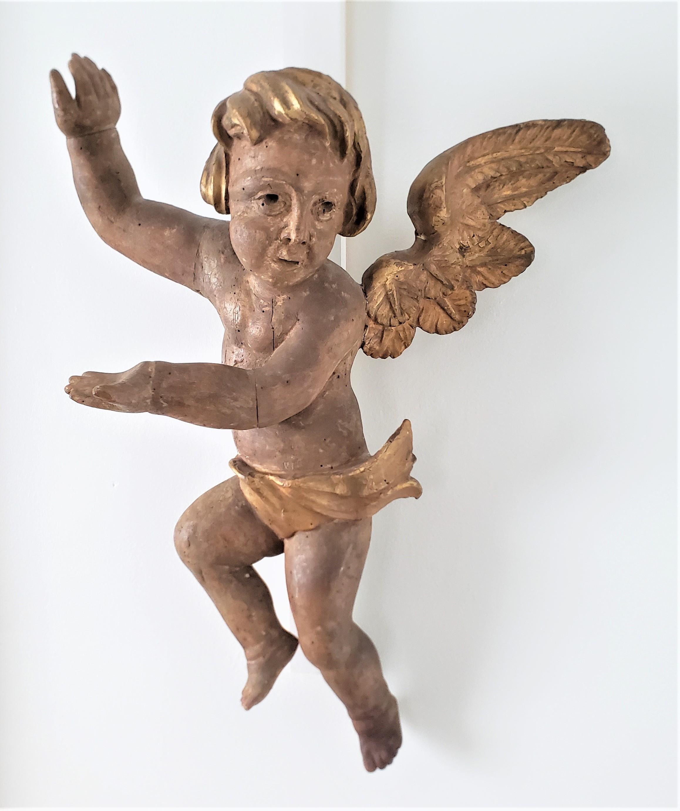 This large hand-carved wooden cherub is unsigned, but presumed to have originated from Germany and dating to approximately 1750 and done in the period Rococo style. The sculpture is composed of a softwood which has been hand-carved and joined in
