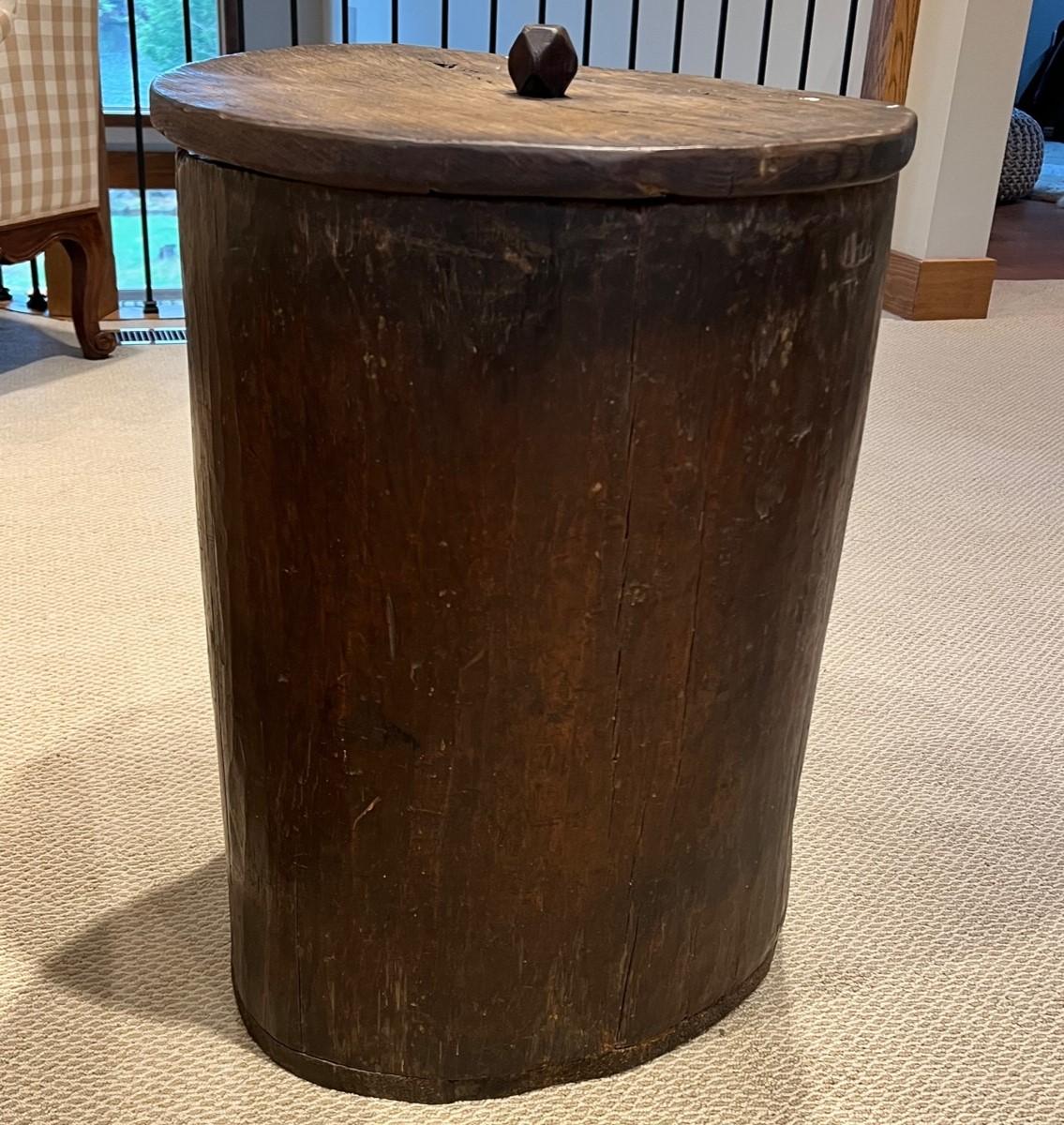 A 19th Century hand hewn tree trunk storage barrel with lid. This large lidded barrel has oodles of character. The organic shape of the barrel retains the shape of the tree from which it was hewn, including the crotch or plume that can be seen on
