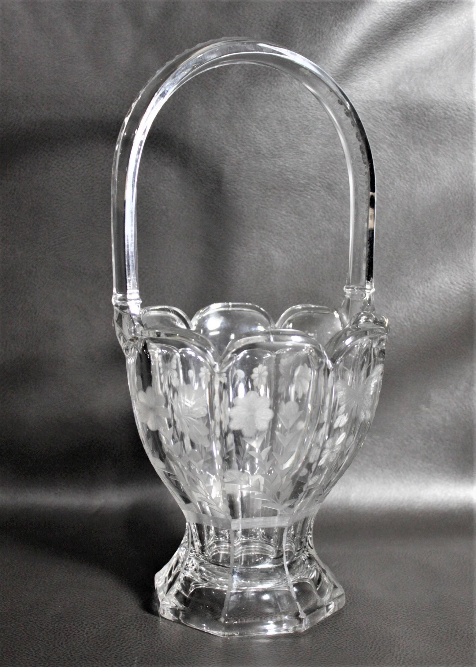 This large crystal basket vase was made by the well known Heisey Glass Company of the United States in circa 1920. This hexagonal shaped vase has deeply etched flowers on each panel with butterflies, alternating between closed and open wings on each