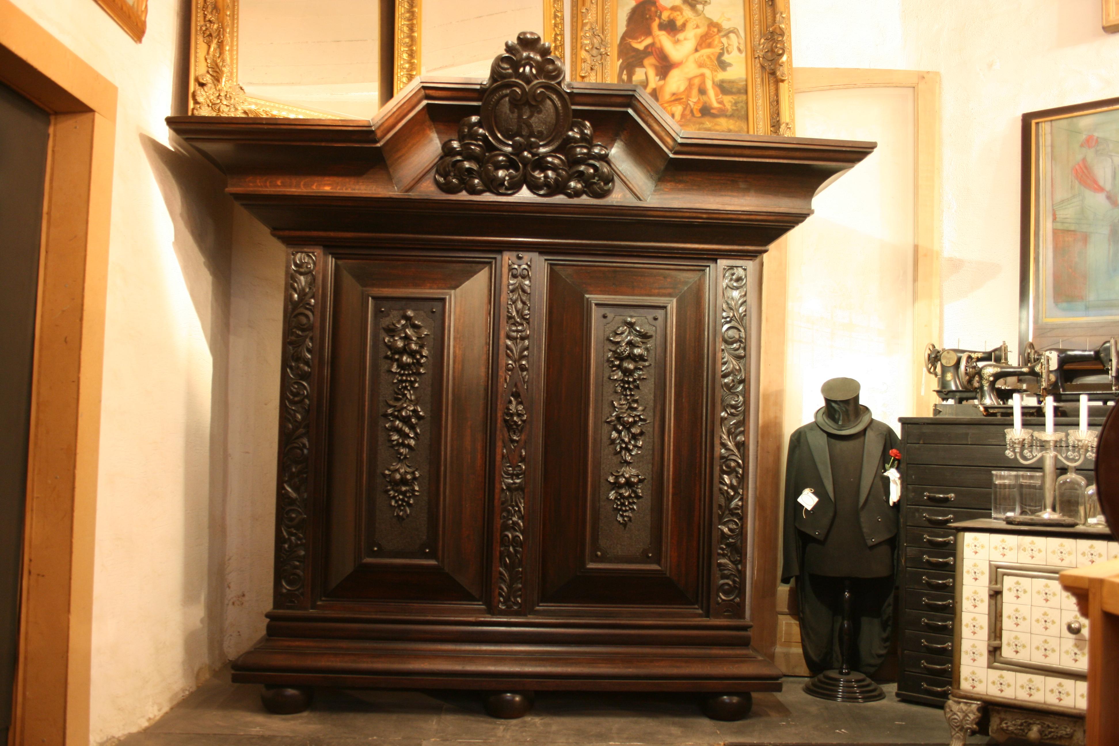 Original old German cushion cabinet or wardrobe / cupboard made of solid oak, from the period of 1880-1920 - Historicism. Inside equipped with shelves. In the enormously big crown a big K initial is carved.
Can be dismantled for transport in several