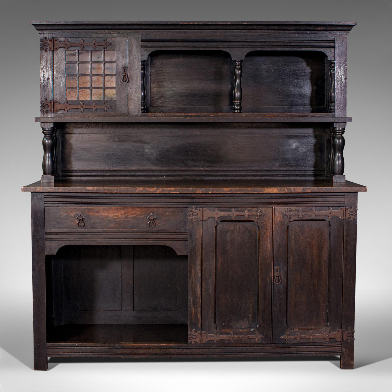 This is a large antique housekeeper's cabinet. An English, oak dresser or sideboard displaying Arts and Crafts taste in the manner of Liberty & Co, dating to the Edwardian period, circa 1910.

Impressive example of the Arts & Crafts movement of