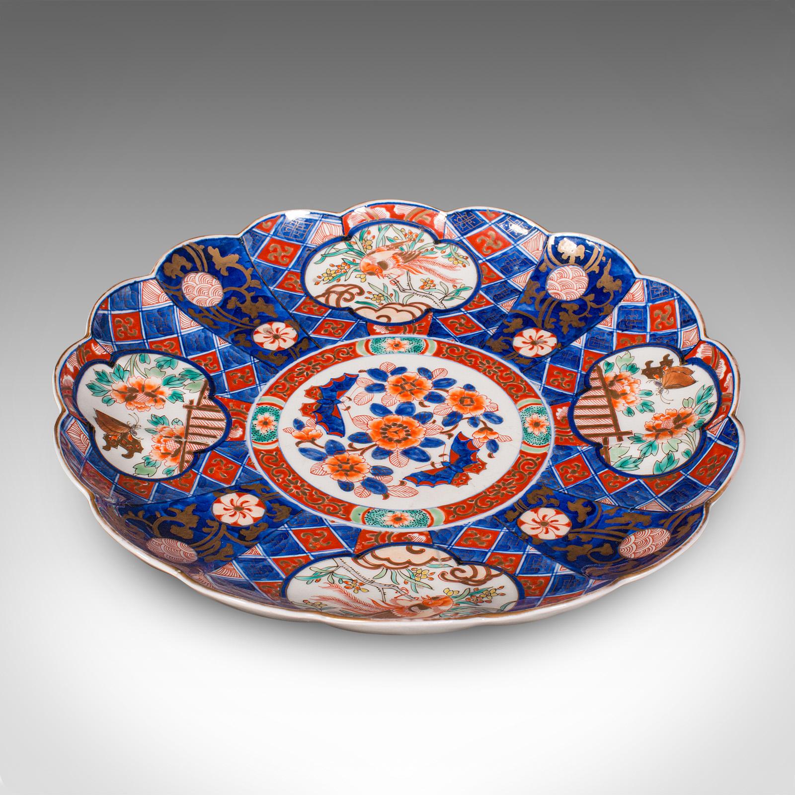 This is a large antique Imari fruit display plate. A Japanese, decorative ceramic celebratory serving platter, dating to the late Victorian period, circa 1900. Wonderfully expressive and generously proportioned, this traditional piece offers