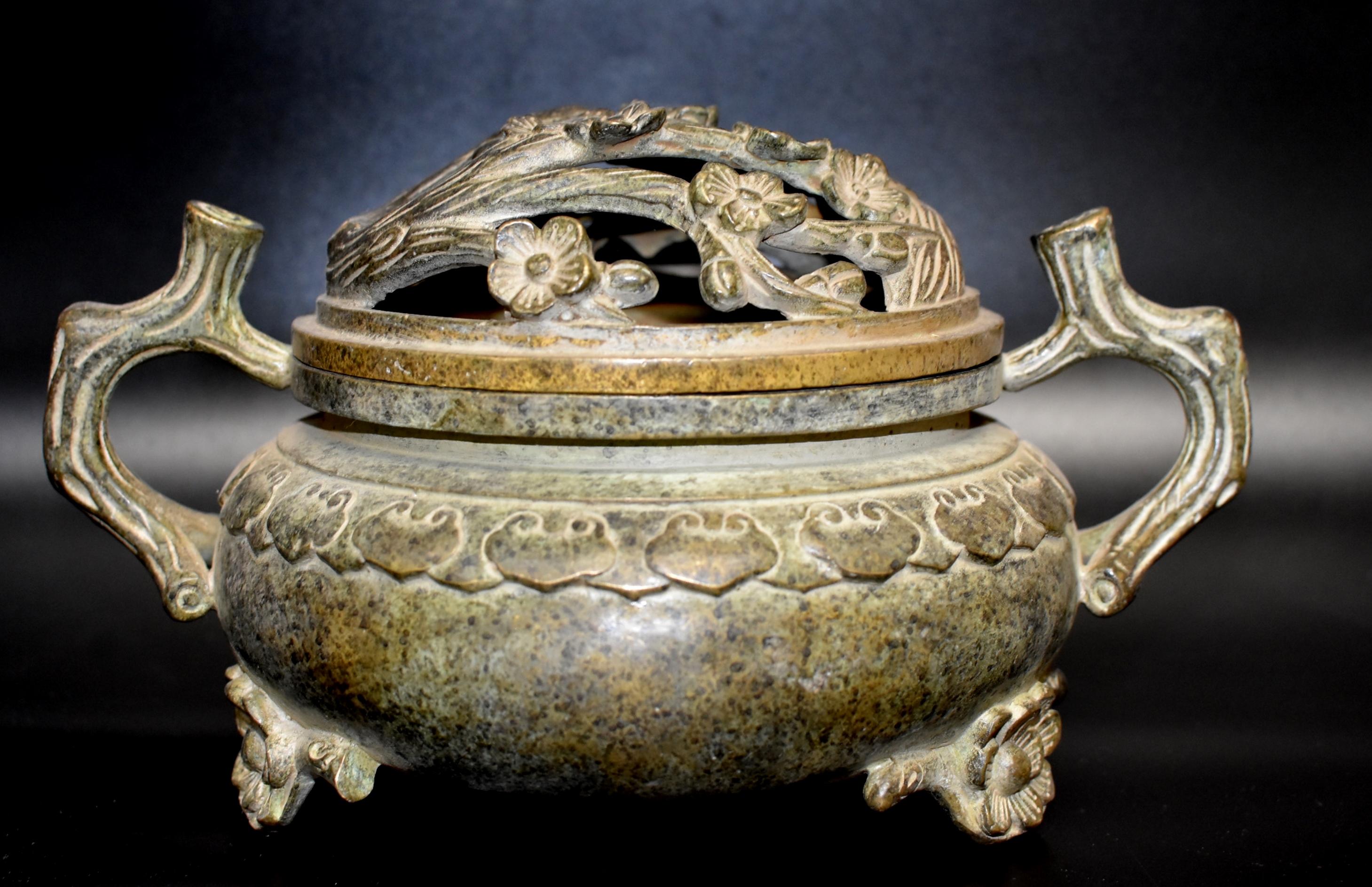 A beautiful, large Chinese incense burner. The pot is decorated with ruyi symbol with lid featuring an open work of branches of plum blossoms. The blossom motif is repeated on the feet. The handles of the burner are branch patterns which echo the