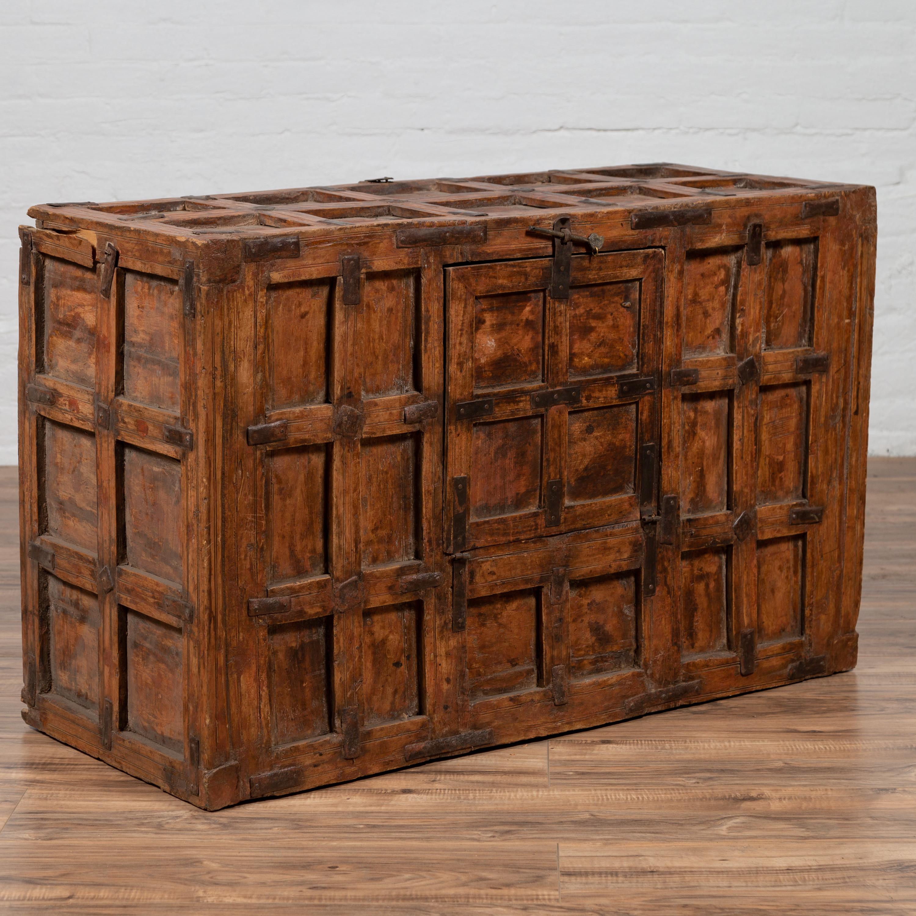 A large antique Indian wooden trunk from the early 20th century, with recessed panels and small frontal opening. Born in India during the early years of the 20th century, this large wooden trunk features a rectangular silhouette, presenting a