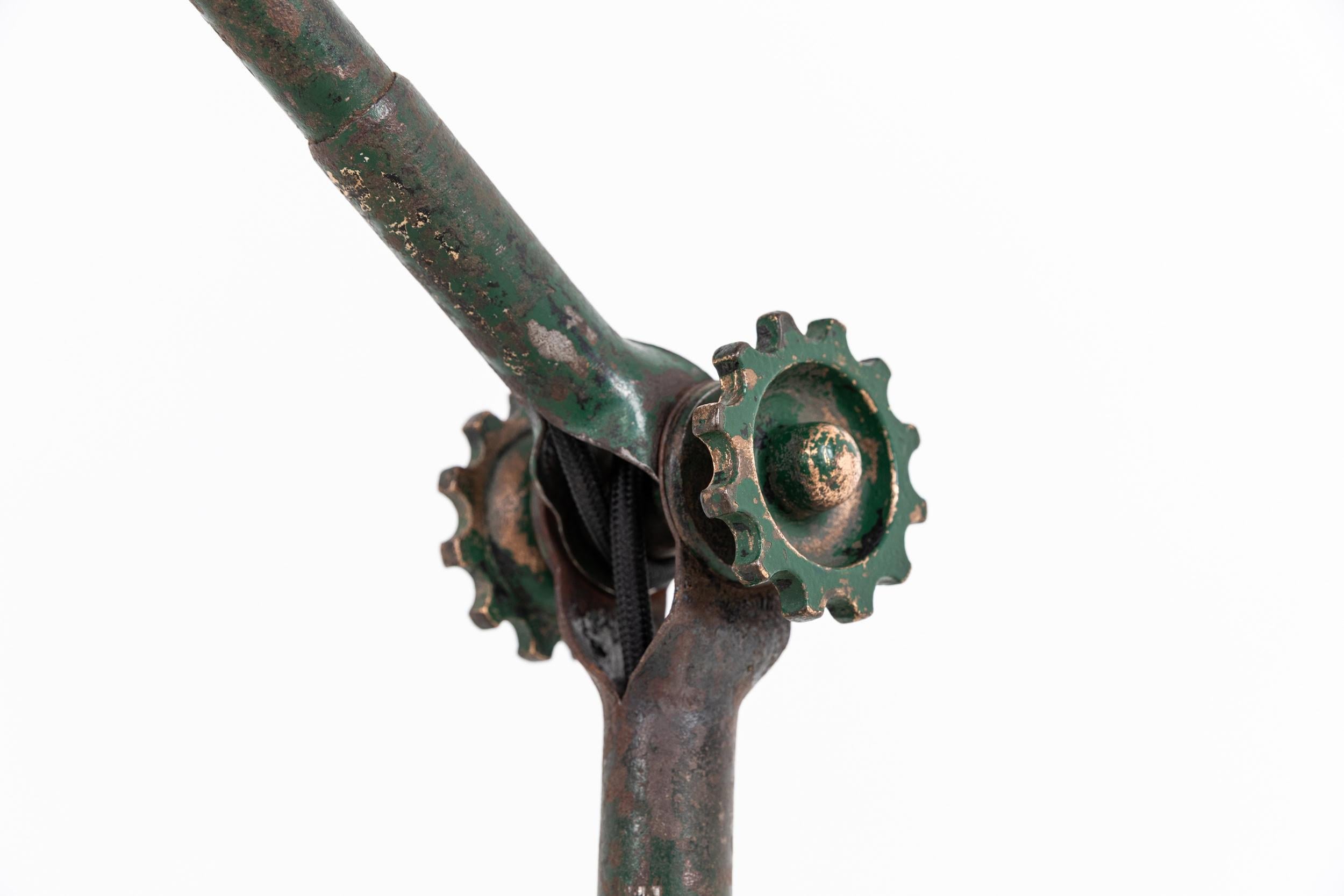 

An original example of an early factory machinist's lamp made in England by Dugdills. c.1910

Manufactured from steel, dry scraped back to reveal the original patinated green painted finish. Featuring the earlier cast brass cogged tightening bolts