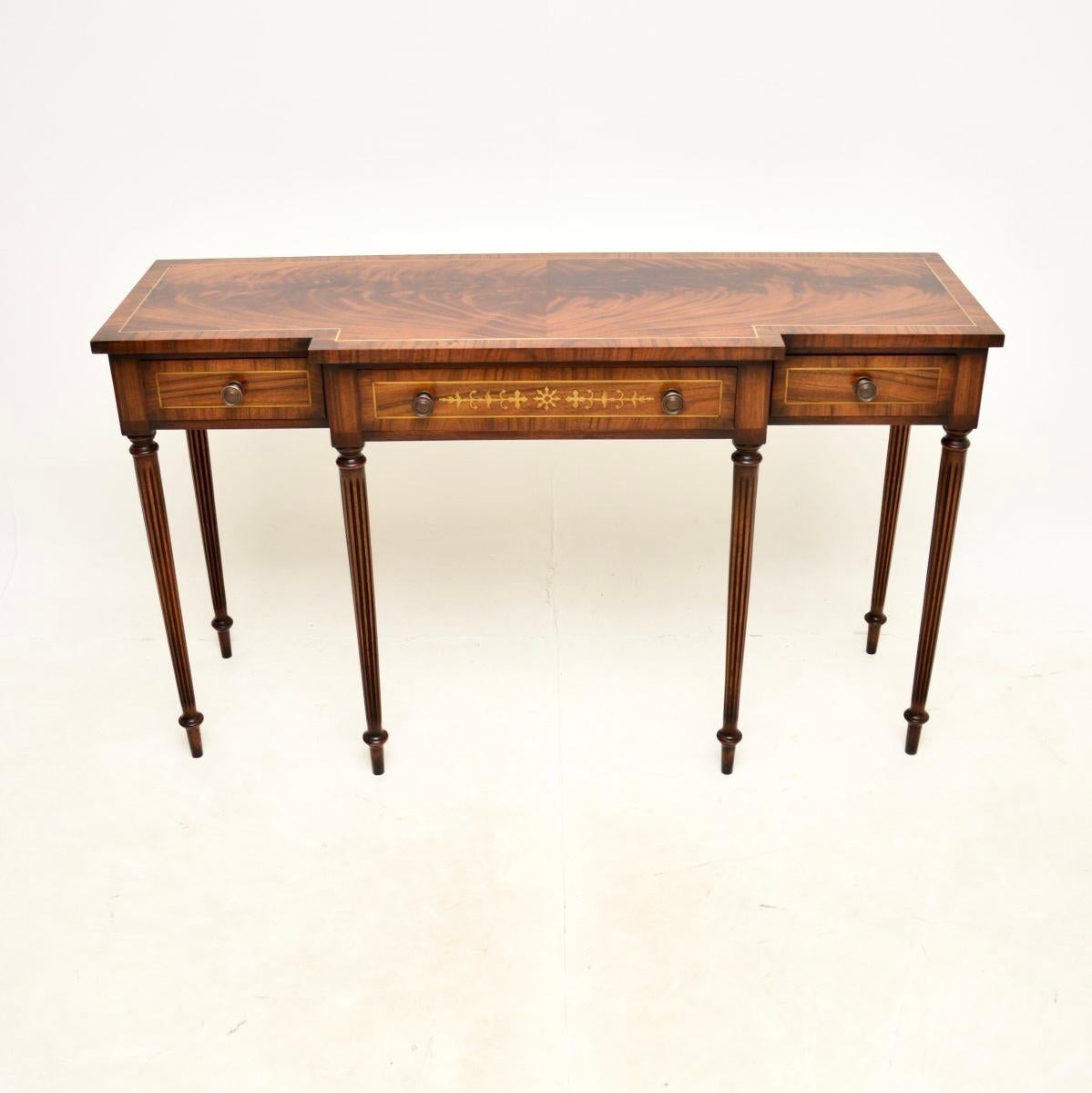 An impressive large antique inlaid brass console table. It is in the Regency style, it was made in England and dates from around the 1950’s.

This is of outstanding quality, the wood has gorgeous grain patterns and the brass inlays compliment it