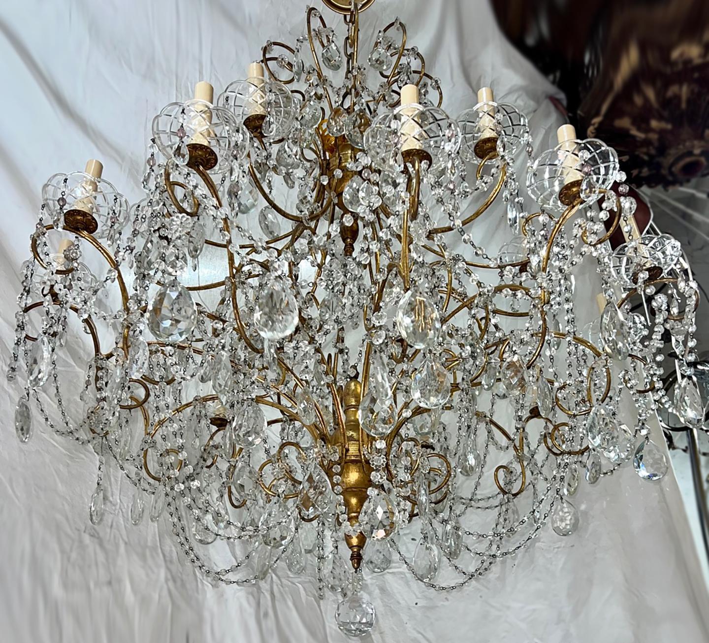 Lustre italien des années 1920 avec pendentifs en cristal et 18 lampes candélabres.

Mesures :
Hauteur : 36
Diamètre : 44