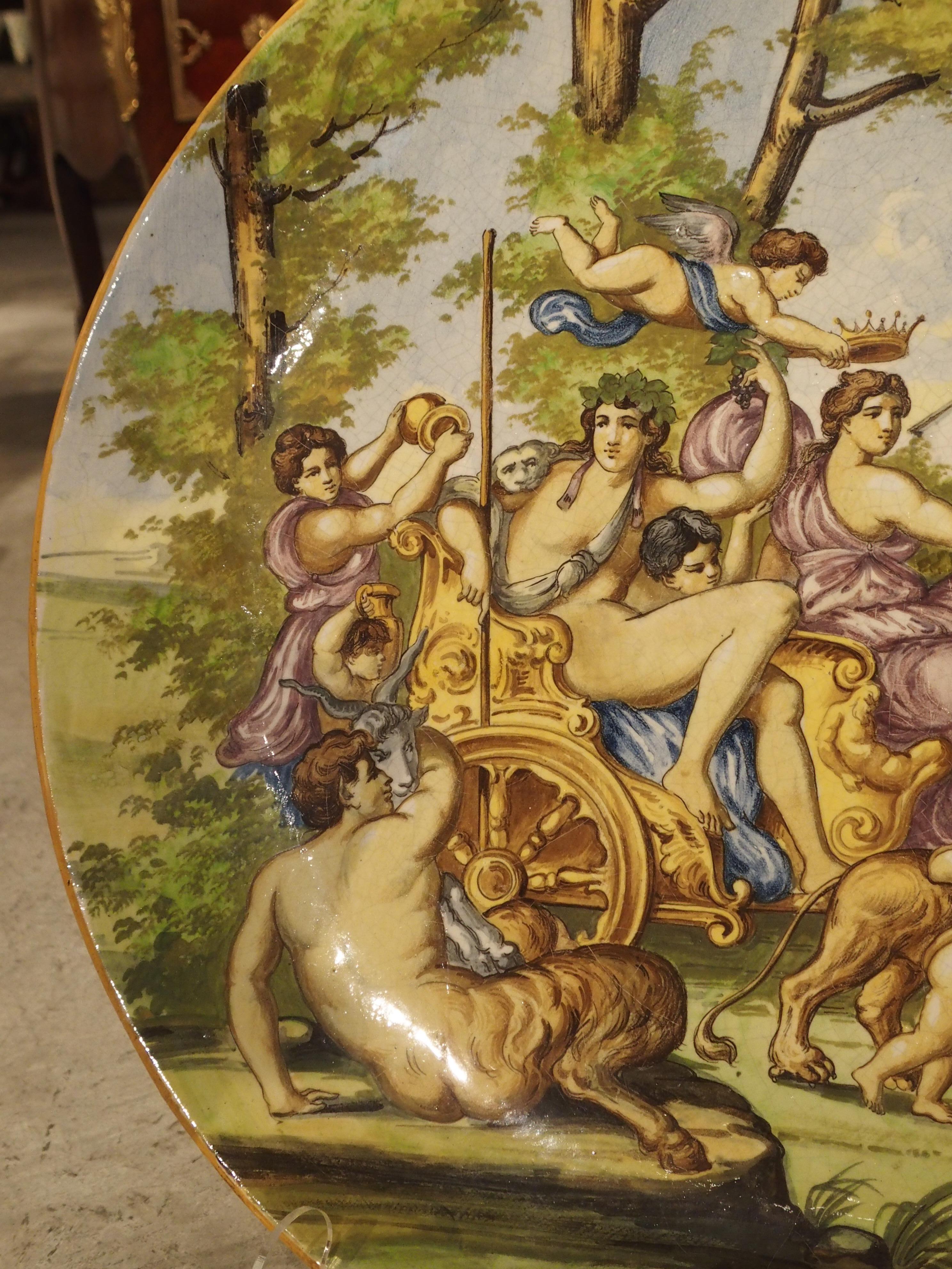 At over two feet in diameter, this stunning majolica platter or charger, is particularly large. The painted scene painted was taken from a ceiling fresco known as the Triumph of Bacchus and Ariadne, by Annibale Carracci in 1597. It was part of the