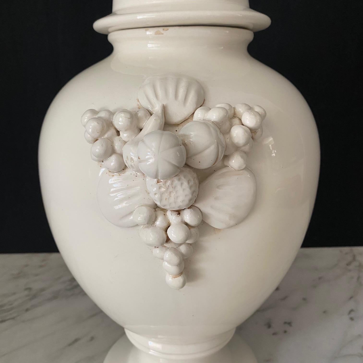 A pair of large Italian white ceramic urn vases with lovely round lids and fruit garlands on the sides. 7 point crown maker's mark on the bases; possibly Capodimente.   Elegant decoration for your home!
#7143
