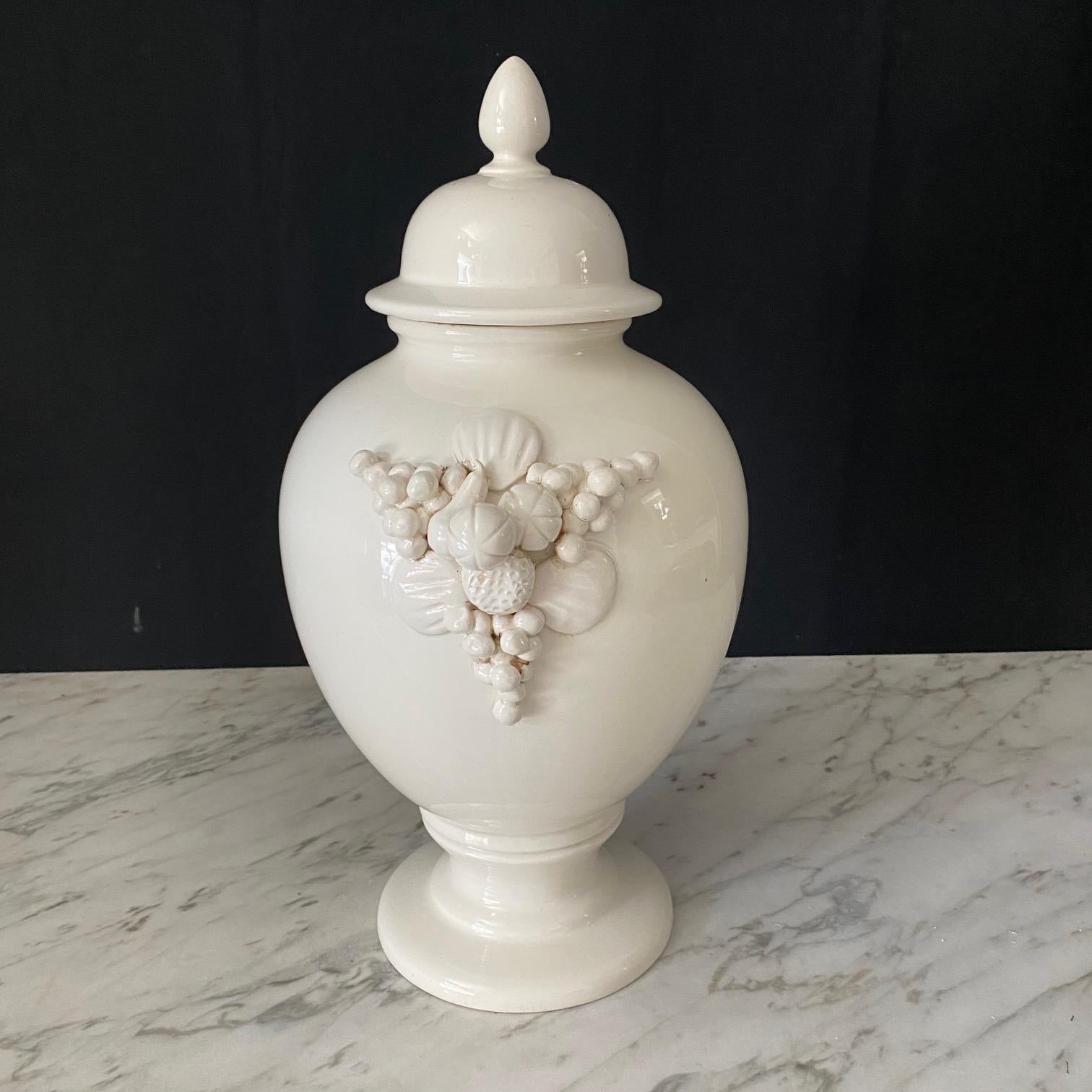 A pair of large Italian white ceramic urn vases with lovely round lids and fruit garlands on the sides. 7 point crown maker's mark on the bases; possibly Capodimente.   Elegant decoration for your home!
#7143