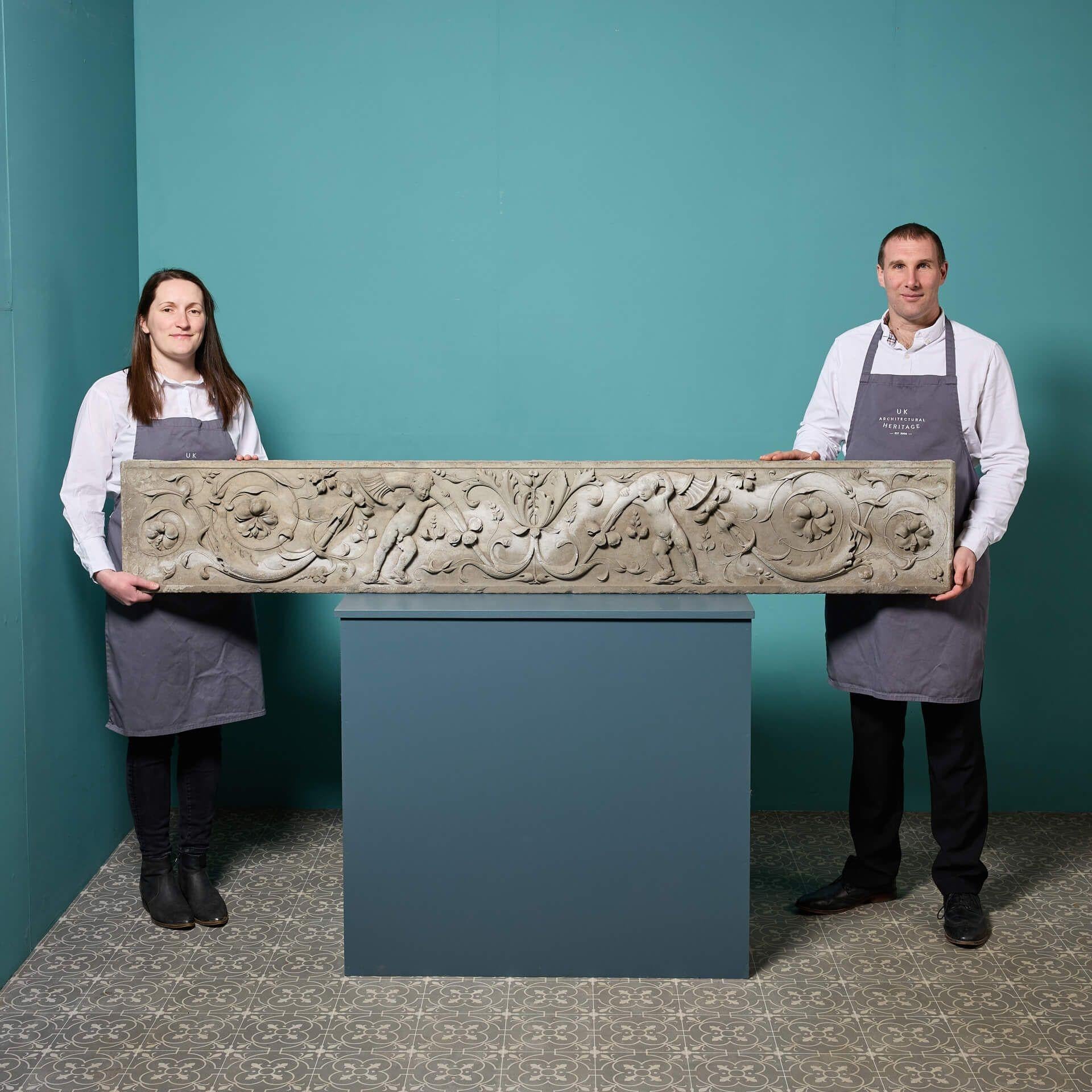 A large antique Italian stone chimney piece frieze dating to circa 1800.

Originally salvaged from a monumental scale fireplace, this frieze displays fine carving in relief depicting two putto holding foliate cornucopia amid flowering scrolls in an