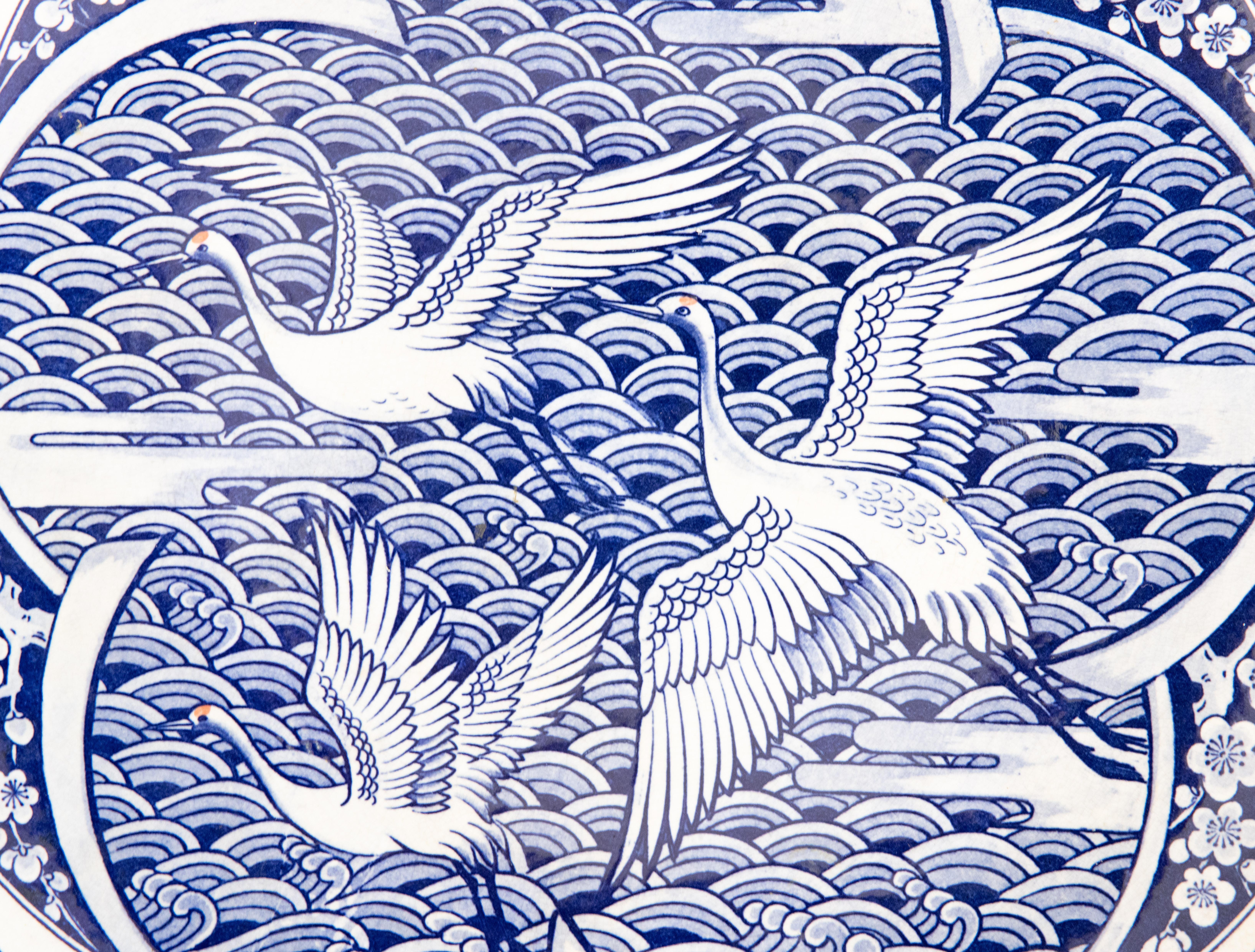 A lovely large antique Japanese blue and white charger depicting three cranes in flight over an ocean accented by cherry blossoms and a decorative floral border. Maker's mark on reverse. It's a nice large size and heavy, weighing over 3 lbs, and
