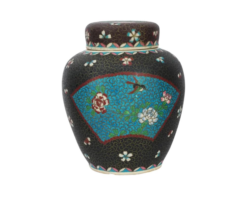 A large antique Japanese late Meiji era covered Totai enamel on porcelain ginger jar. Circa: late 19th century to early 20th century. The ware is enameled with a polychrome fan shaped medallions with blossoming flowers, and butterflies, surrounded