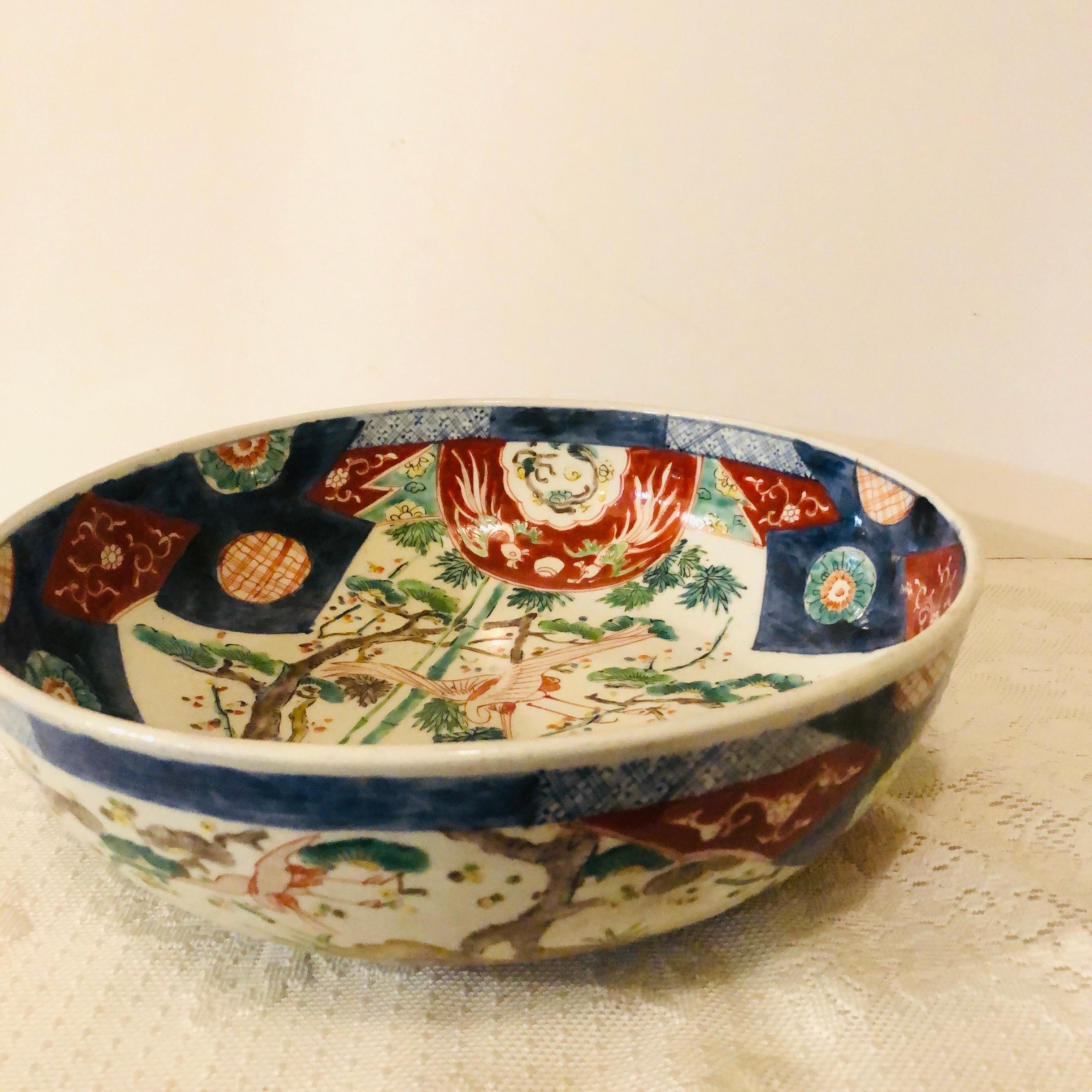 I want to offer you this large Japanese Imari bowl with paintings of whimsical birds and trees with an Imari color palate decoration. You can see the whimsical painting on this bowl in the video. It is painted on all sides of the bowl and also in