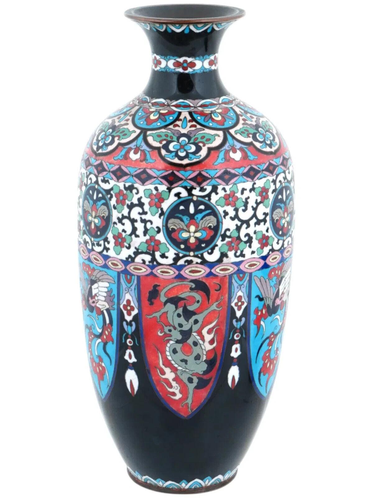 Gran jarrón antiguo japonés de cobre con diseño de esmalte cloisonné. Finales del periodo Meiji, antes de 1912. Forma alargada con cuello pronunciado. Paneles con motivos florales y dragones en colores primarios sobre fondo negro. Decoración