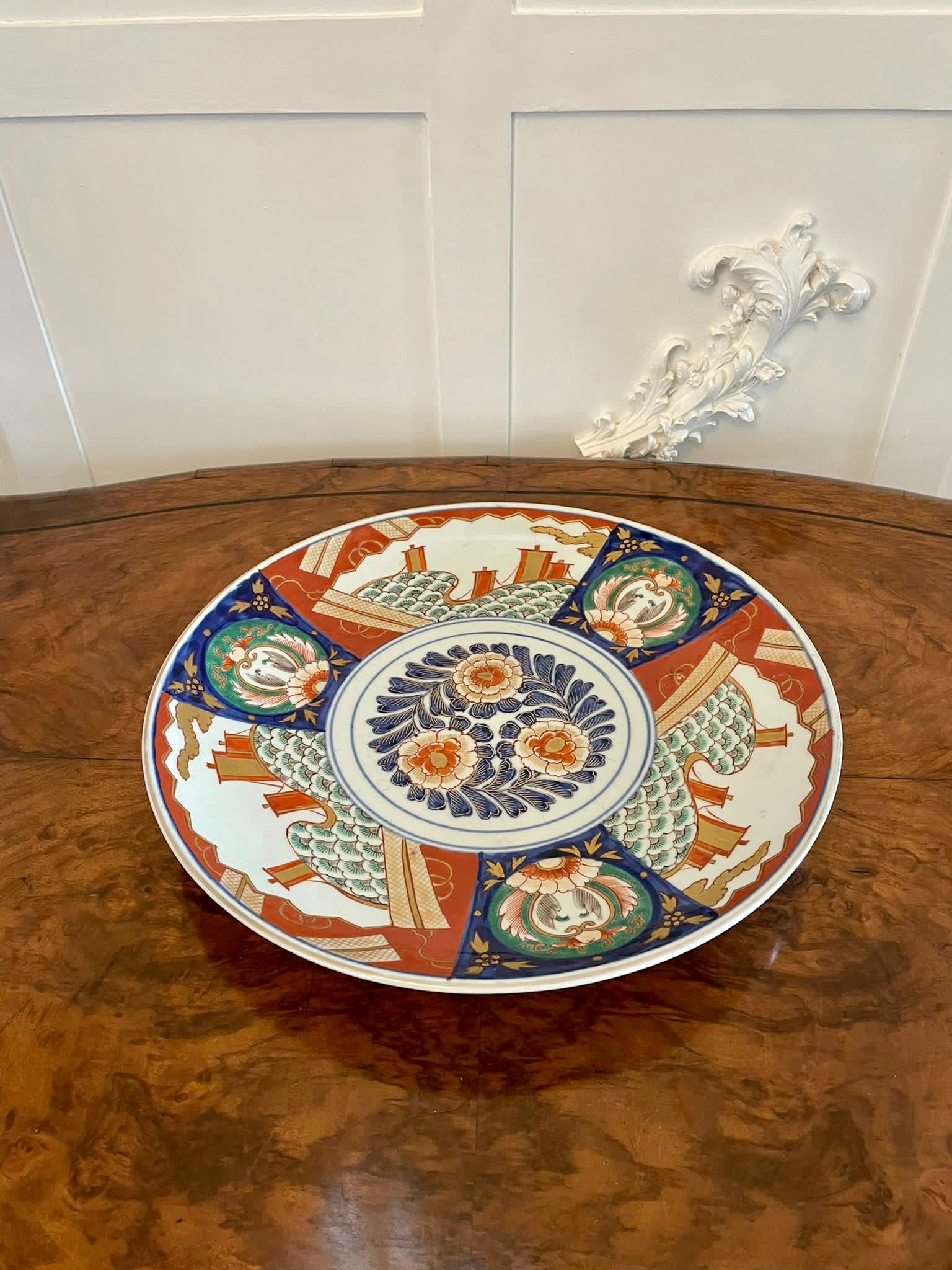 Large antique Japanese quality Imari charger having quality hand painted panels with flowers, leaves, trees, birds and ships in wonderful green, blue, red, white and gold colours 

In perfect original condition.

Measures: H 5cm
W 38cm
D