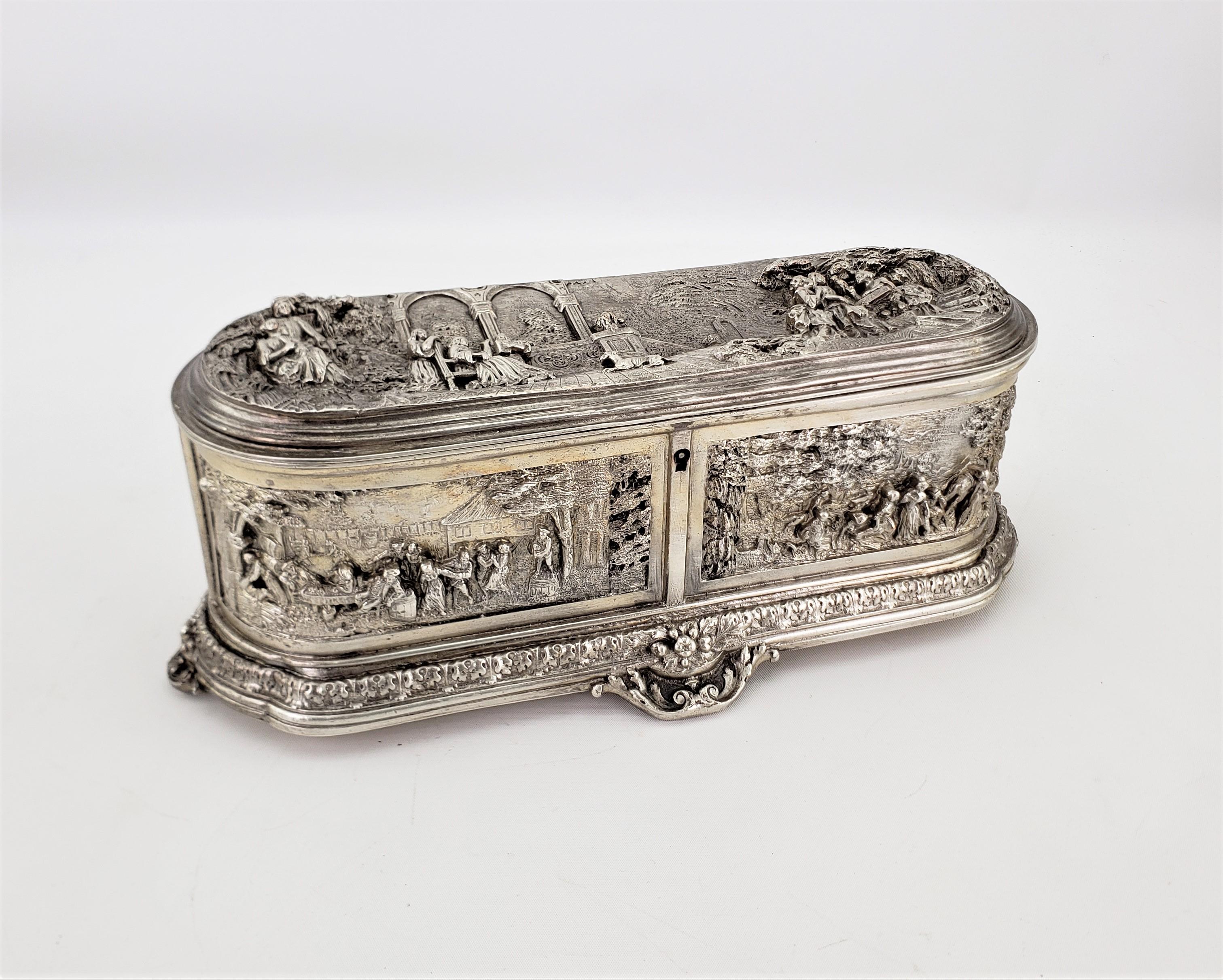 This large and antique jewelry casket is unsigned, but presumed to have originated from France and dates to approximately 1920 and done in a Renaissance Revival style. The jewelry box is composed of pressed metal with a black patination and depicts