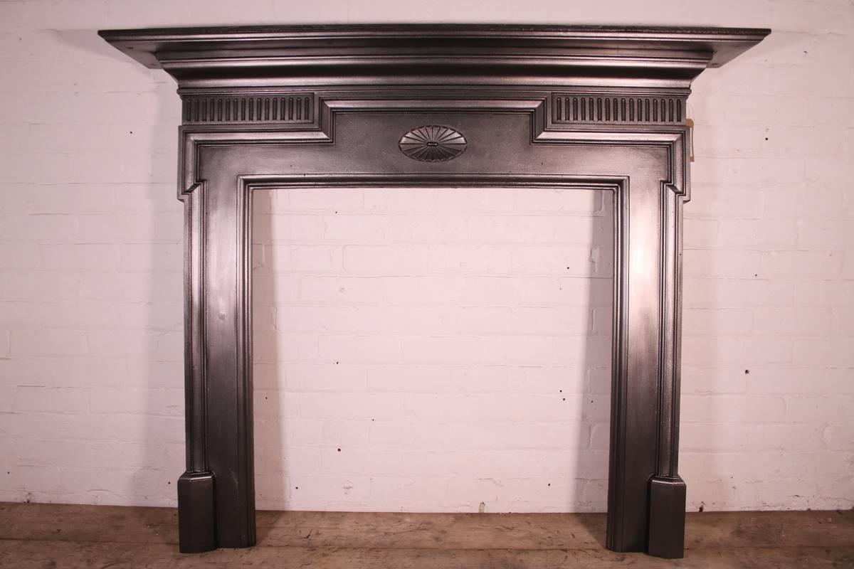 Large antique late Victorian cast iron fire surround with dog leg moulding to the jambs and a simple rosette to the frieze, circa 1895.

Finished in traditional black grate polish giving a gun metal sheen. This finish can be changed if required,