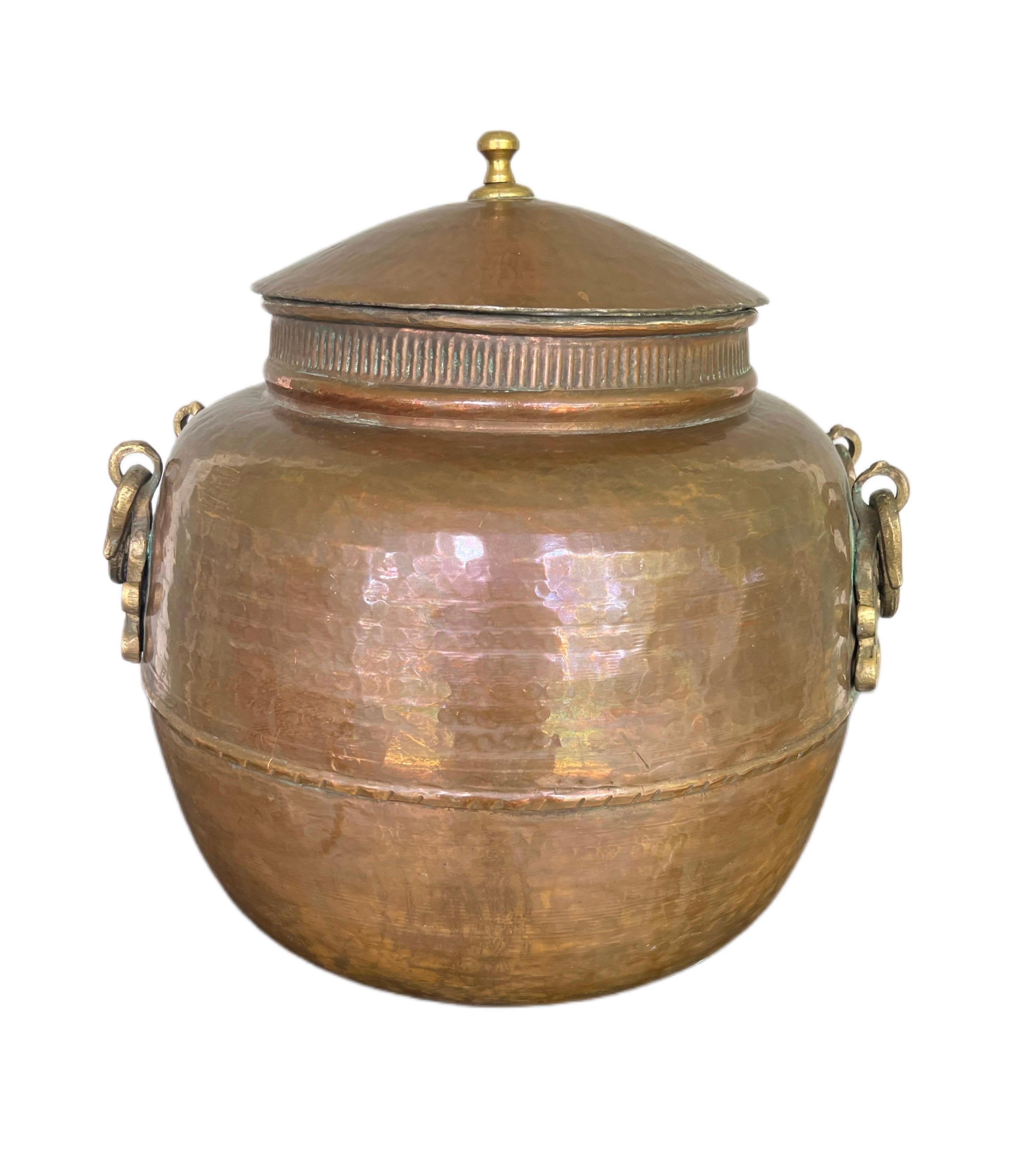 Amazing large antique handmade hammered cauldron/ lidid pot, has heavy ornamental brass handles on each side.  
Beautiful all around, in amazing condition that could be use to store any items of your choice. A very unique decor item for your