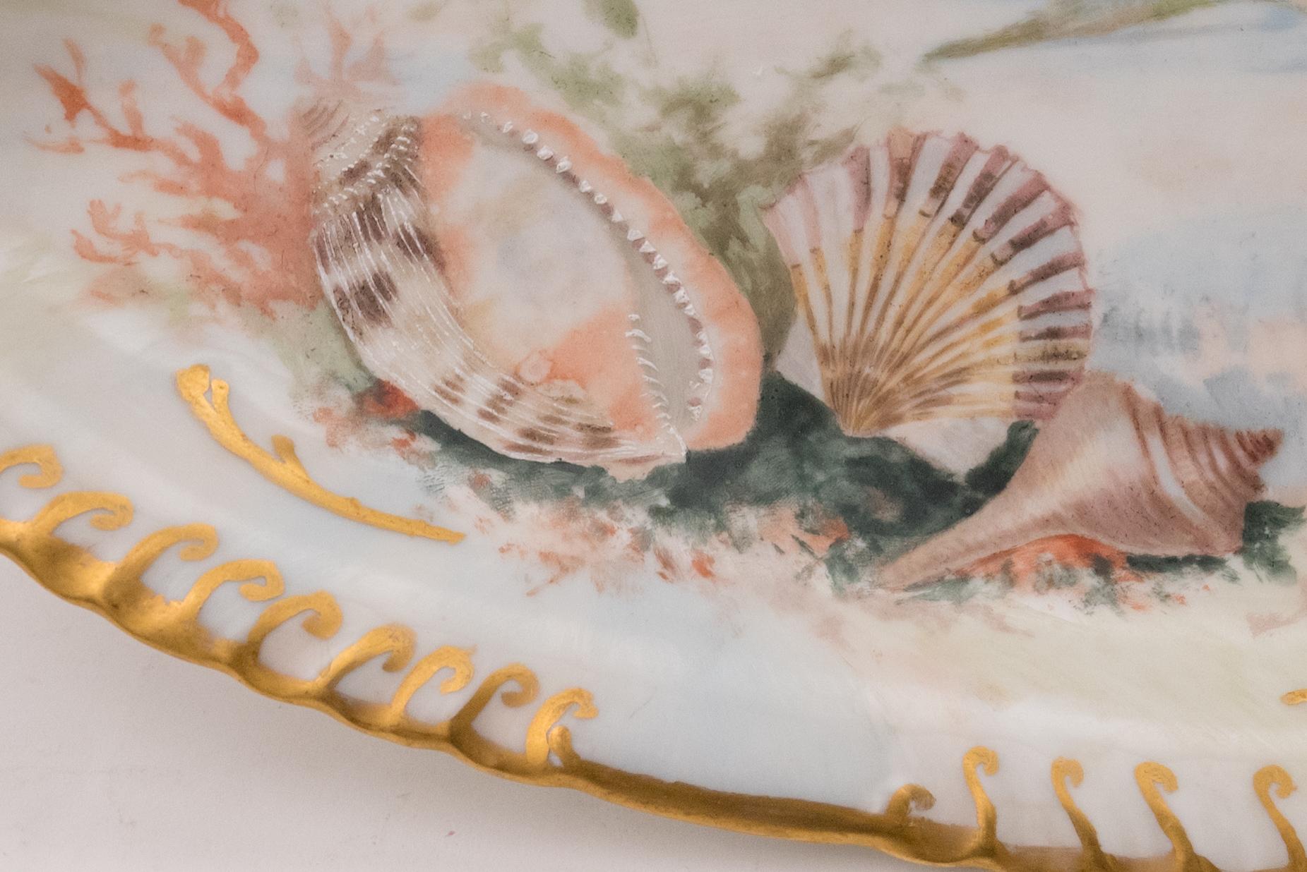 A large platter ready for your fish service or to be a great accent piece to your display cabinet. This piece has a nice scalloped shape to the rim and is hand painted with a central fish and sea shell, coral, fauna accents. In really great antique