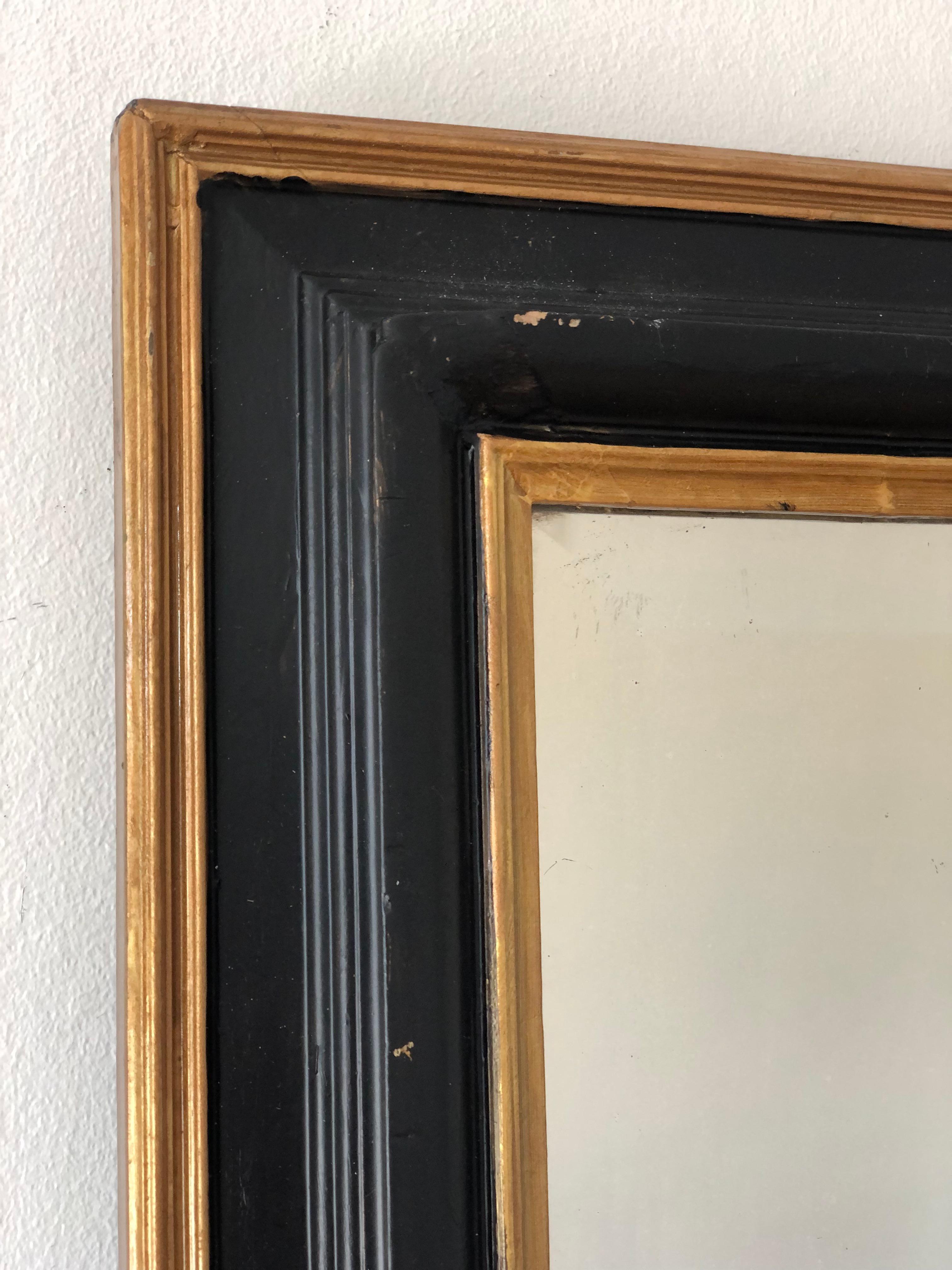 Antiker französischer Louis Philippe Spiegel mit abgeschrägtem Glas aus dem späten 19. Jahrhundert. Er hat einen schwarzen Rahmen mit zarter Goldverzierung und eine geschwungene Oberseite. Der geschnitzte schwarze Rand verleiht dem Rahmen eine