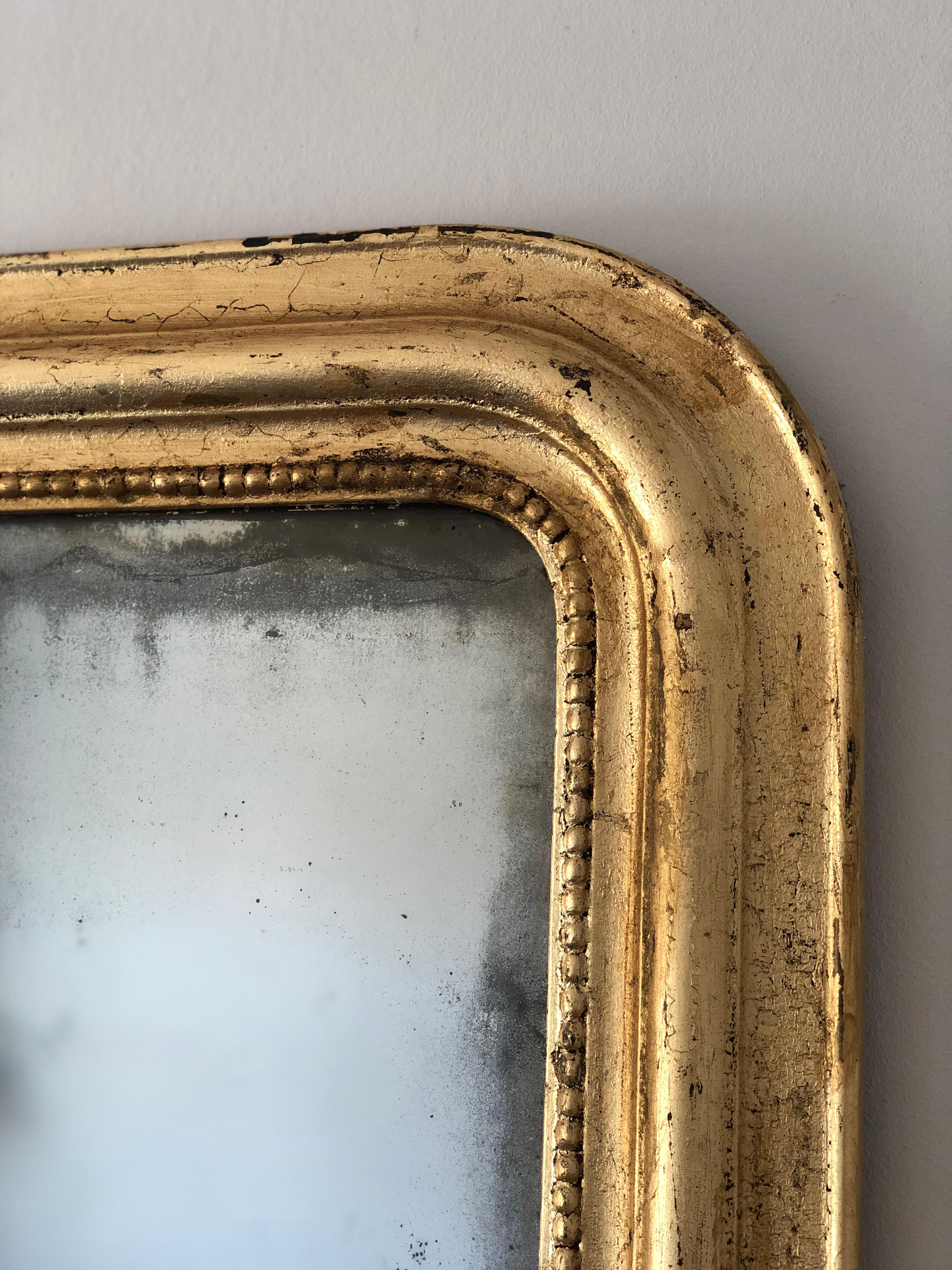 Un antico specchio Louis Philippe proveniente dalla Francia, risalente alla fine del XIX secolo.
Con un aspetto grandioso, la cornice in legno dorato intagliato presenta angoli superiori graziosamente curvati, una bella patina di foglia d'oro