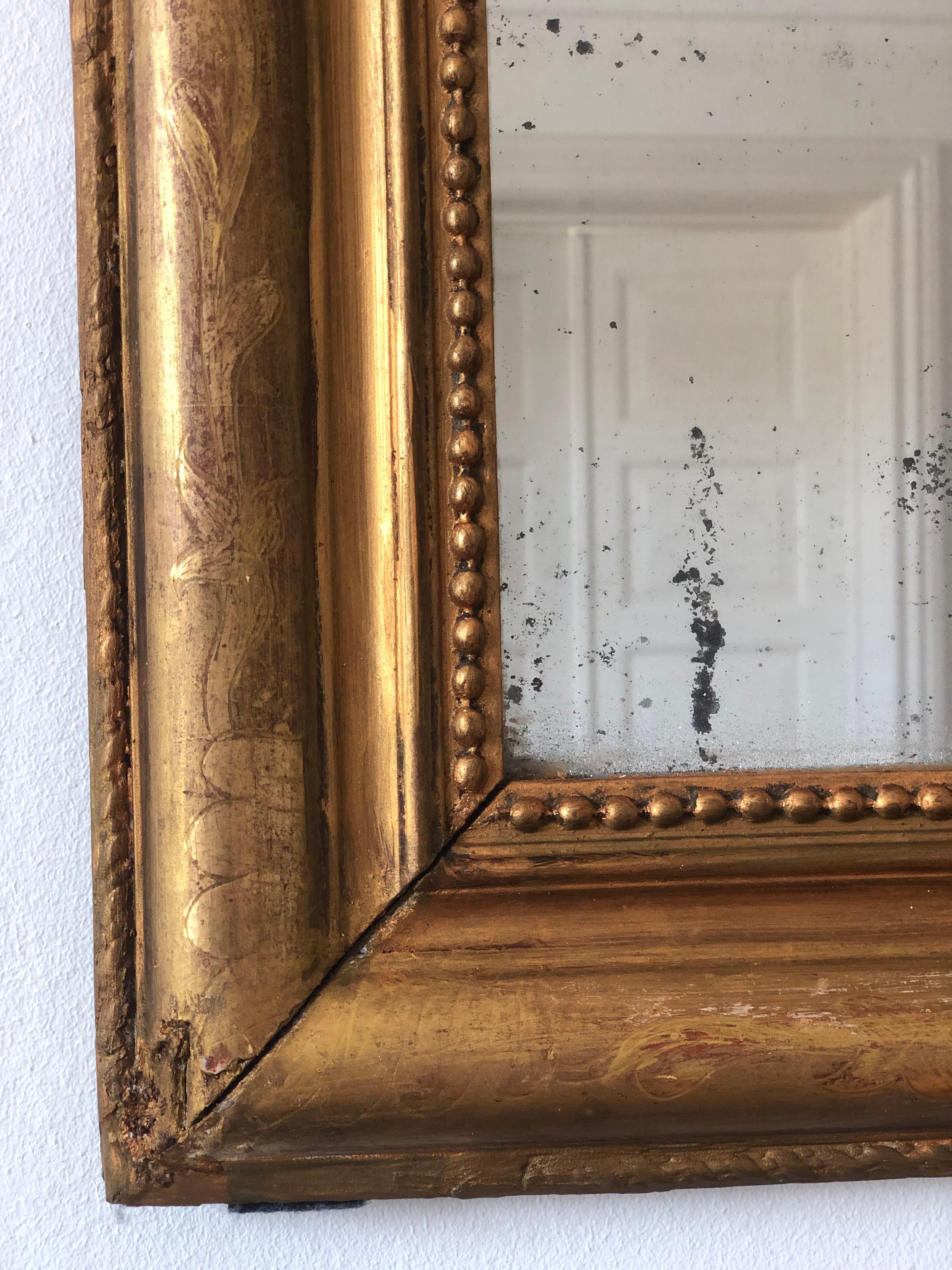 Un antico specchio Louis Philippe proveniente dalla Francia, risalente alla fine del XIX secolo.
Con un aspetto grandioso, la cornice in legno dorato intagliato presenta angoli superiori graziosamente curvati, una bella patina di foglia d'oro
