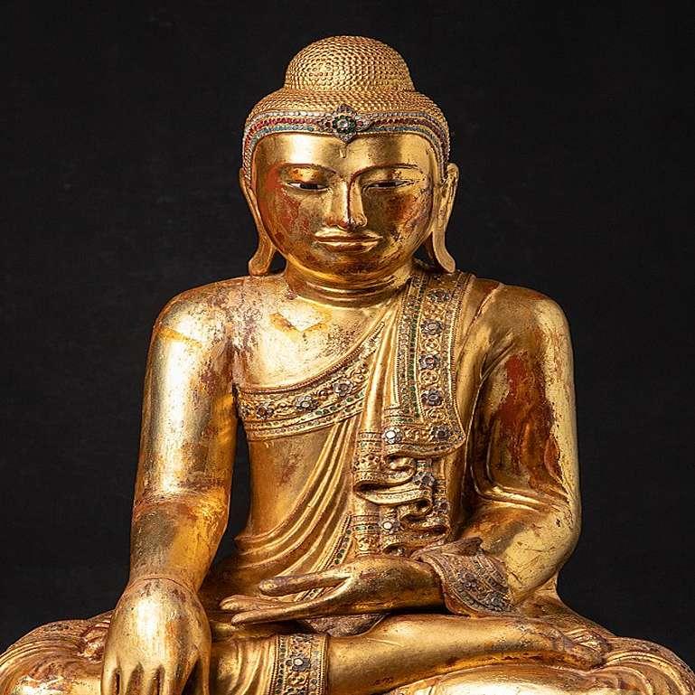 Material: wood
71,7 cm high 
58 cm wide and 44,3 cm deep
Weight: 23.3 kgs
Gilded with 24 krt. gold
Mandalay style
Bhumisparsha mudra
Originating from Burma
19th century
With inlayed eyes
 