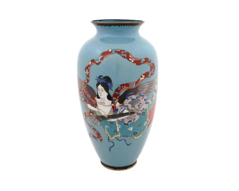 A large antique Japanese Meiji era, 1868 to 1912, cloisonne enamel vase decorated with an image of tennin, a beautiful winged woman dressed in ornate kimono with a flowing scarf that wraps loosely around her body on a sky blue ground. This vase