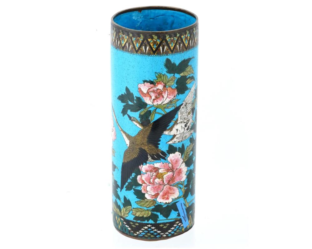 A large antique Japanese late Meiji Era cylindrical shaped enamel over copper brush pot. Circa: late 19th century. The cylindrical form pot is enameled with a polychrome image of geese in blossoming flowers made in the Cloisonne technique. The base