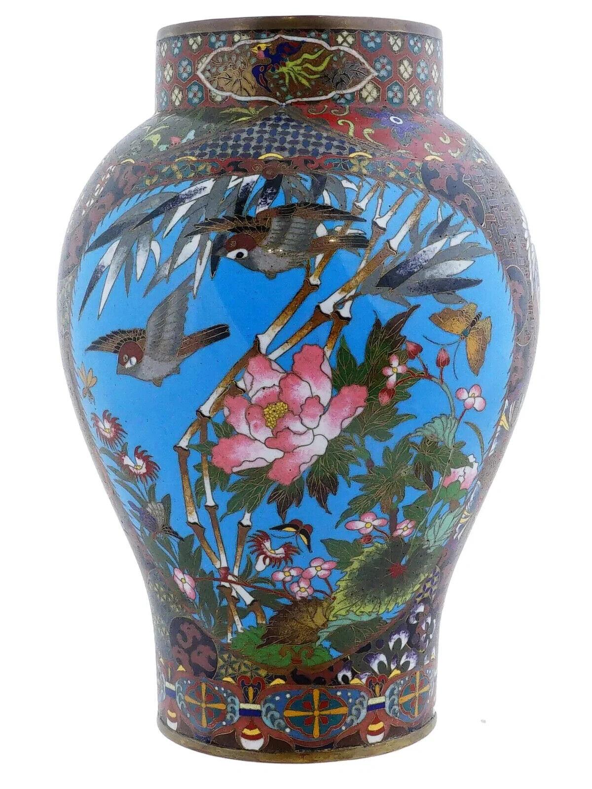Un antico vaso giapponese in smalto cloisonne dell'epoca Meiji. I vasi hanno un corpo a forma di balaustro. Presenta medaglioni blu ornati da motivi floreali e uccelli smaltati. I medaglioni sono su una base rossa con un motivo a fogliame e motivi