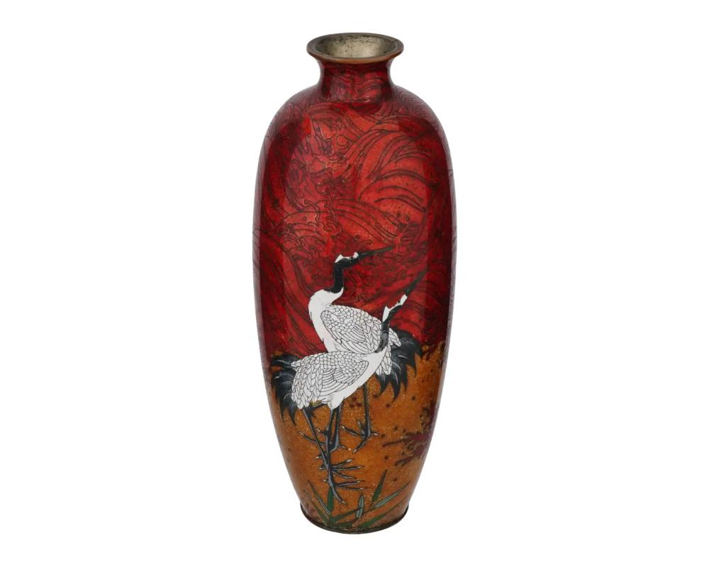 Grand vase japonais ancien en cuivre à décor d'émail cloisonné translucide. 1890 ère Meiji, . Forme allongée avec un cou prononcé. La pièce est décorée d'un motif d'oiseau cigogne sur fond rouge et jaune. Art et décoration orientaux de collection