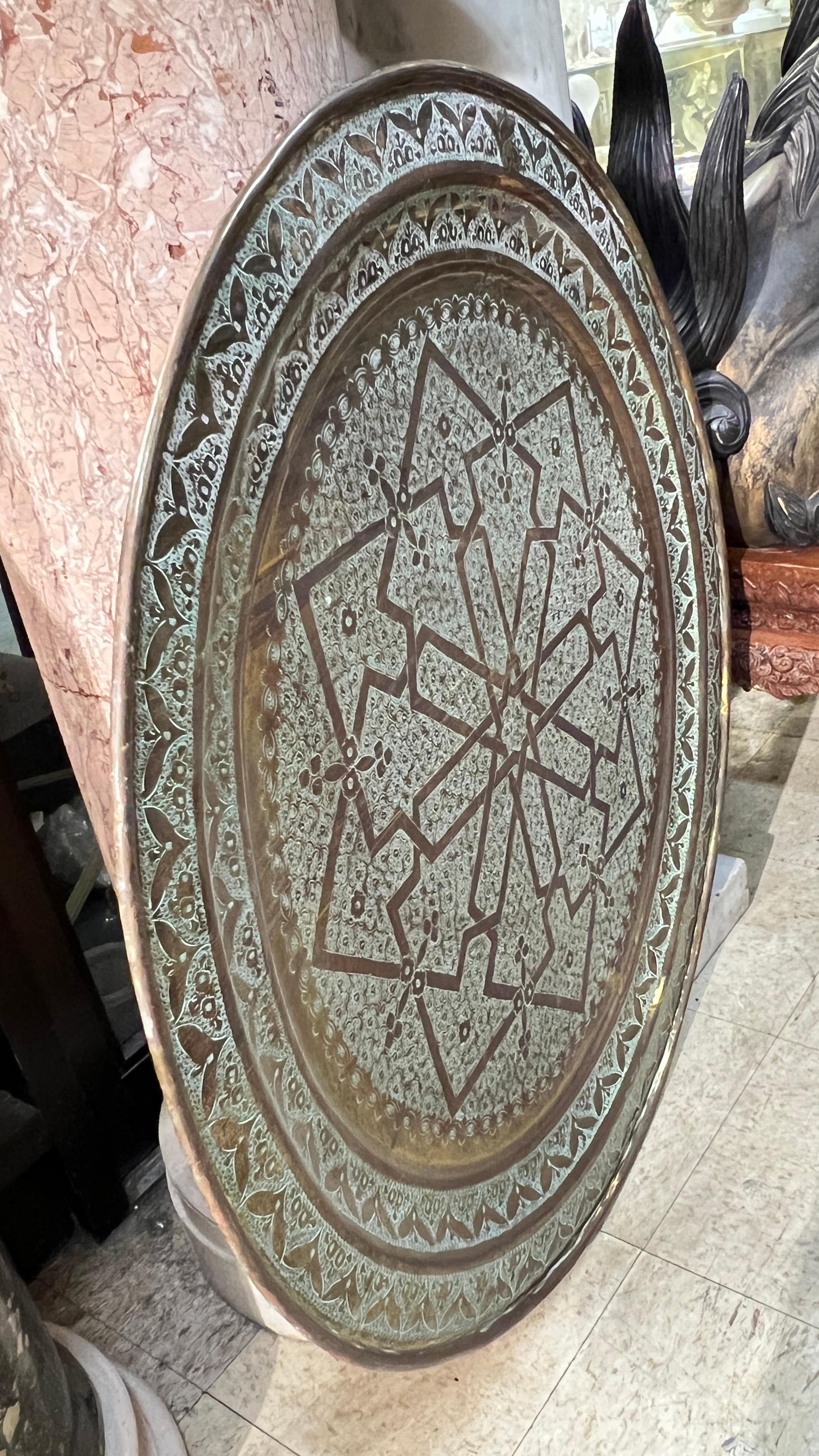 Large antique Islamic brass tray with fine geometric engraved designs measuring 37 1/2 inches across.  Likely of Morrocan or Egyptian origin.