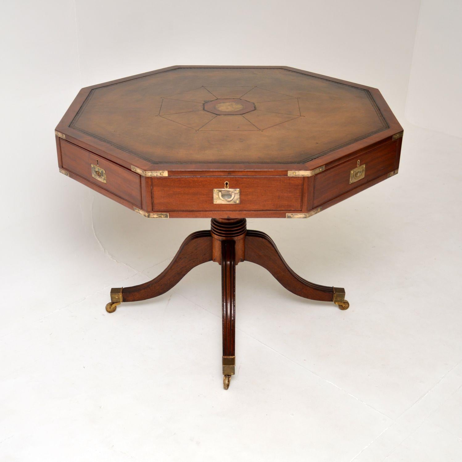 A superb and very large antique military campaign drum table.

We believe it’s antique Regency from the 1820-30 period. It has an octagonal shaped top, with aged brass corner mounts, sunken aged brass military handles & aged brass capped feet on
