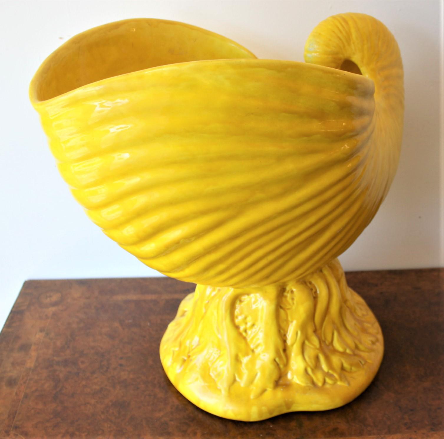 This enormous yellow majolica figural shell jardinière was made by the renowned Minton's factory of England in approximately 1850 in the period Victorian style. This large and substantial planter is done in a very vivid yellow with brown undertones