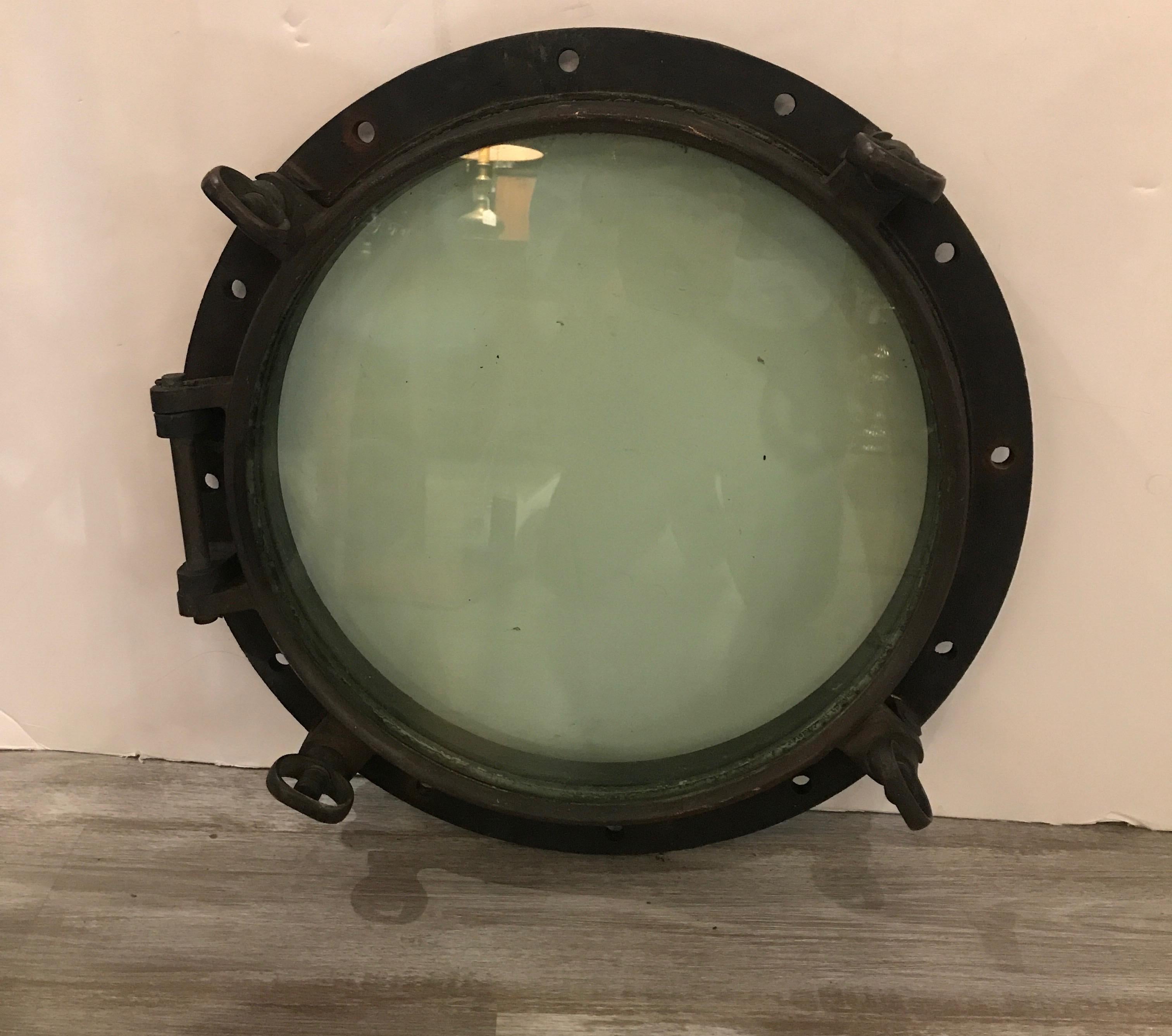 Original condition, large bronze and glass porthole from a turn of the century vessel. 23 inches in diameter, solid cast bronze with original weathered patination. The porthole is in working condition.