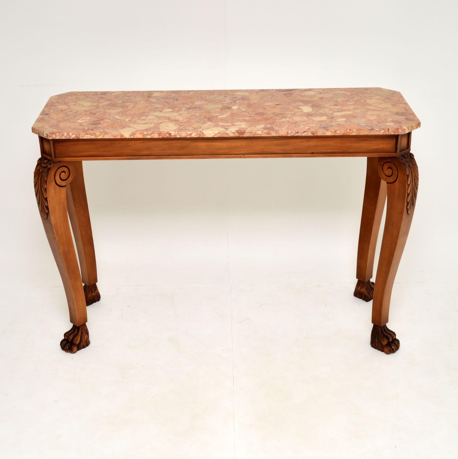 A large impressive and very well made marble top console table in the antique neoclassical style & dating from around the 1950-60’s period.

It is of great quality, with all solid wood construction and Fine, intricate carving. The marble top has a