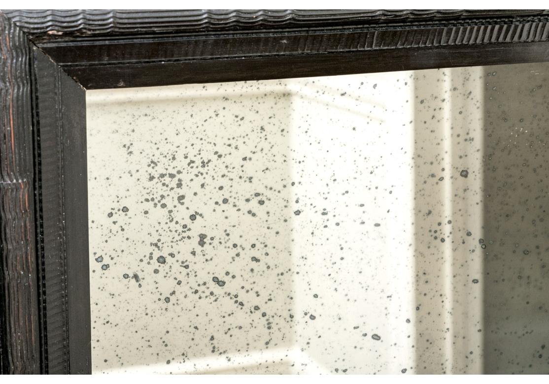 A classic antique Netherlands ebonized mirror with a deep stepped surround. Made up of different bands with incised and wavy linear details with large square corners all made in tiers.

Dimensions: 49