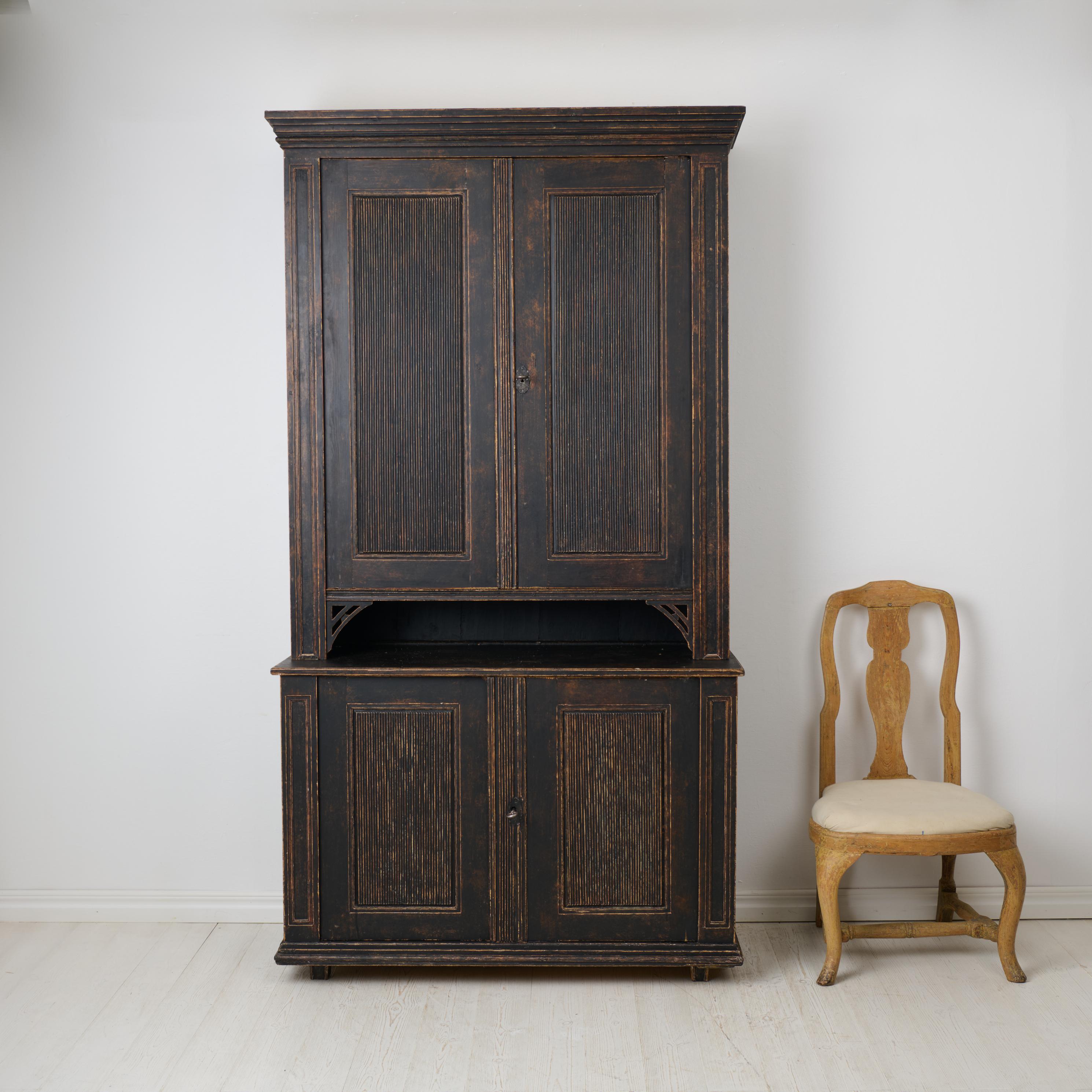 Large antique Swedish cabinet from the gustavian period around year 1800. From northern Sweden made by hand in solid Swedish pine. The cabinet is made in two parts with a classic straight shape and period-typical gustavian decorations. Functional