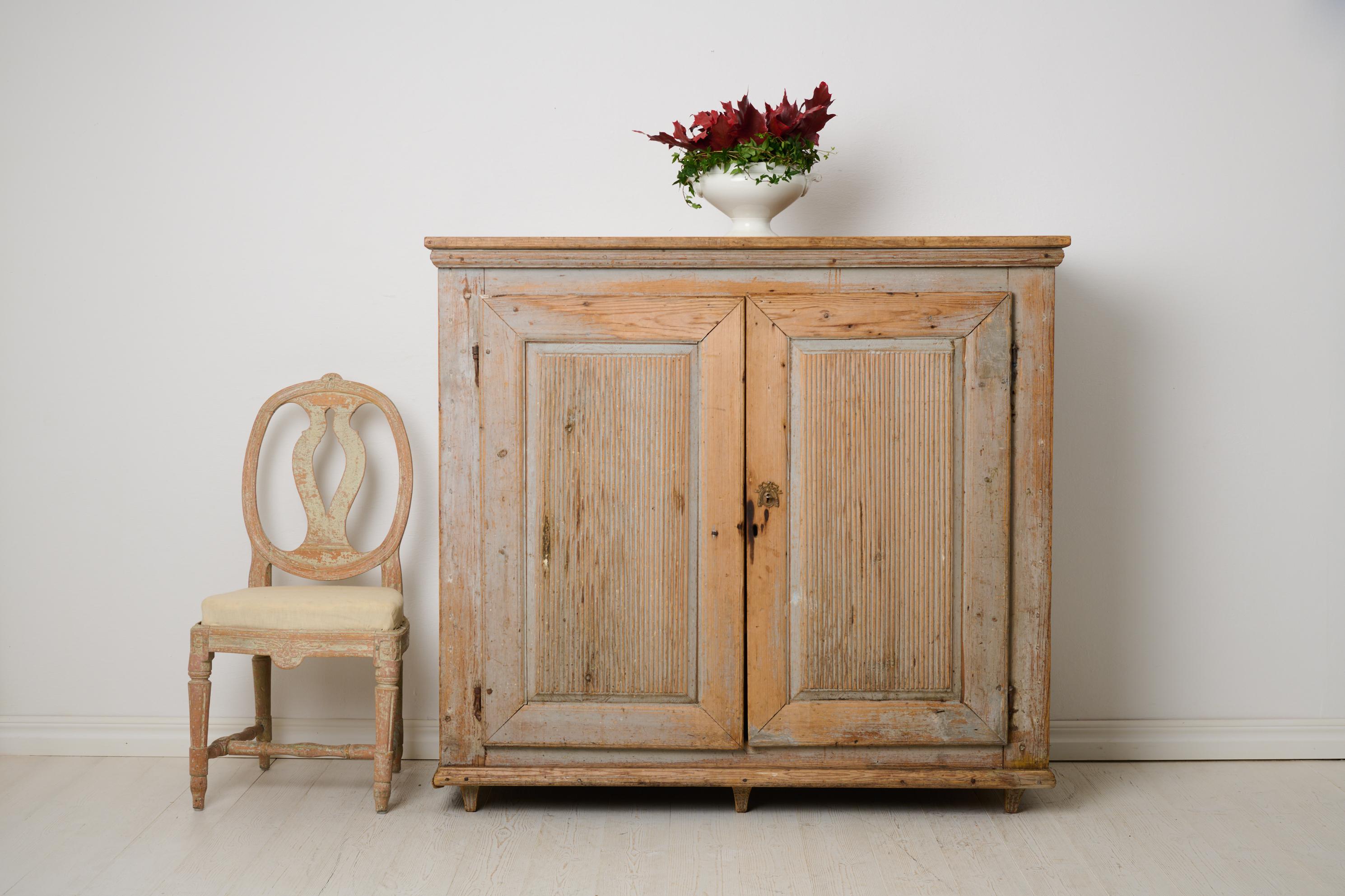 Large antique gustavian sideboard from the late 1700s. This country house furniture has its origin in the area surrounding Ljusdal in northern Sweden. Made by hand in solid pine in classic gustavian style with straight shapes and fluted doors. The