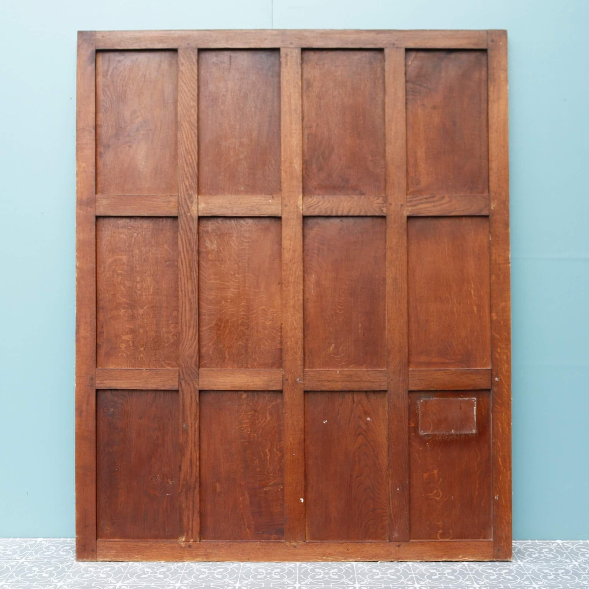 A single large antique oak wall panel salvaged from a British church. It dates from the early 1900s during the Victorian era and features solid oak construction with a rich warm wood colour. It is double sided with panels to both the front and back,