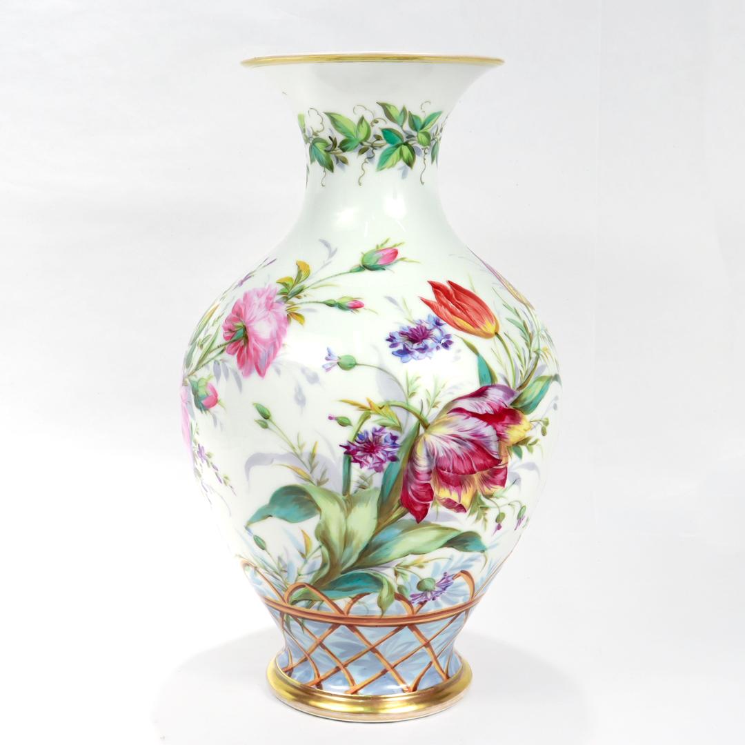 A fine large antique porcelain baluster vase.

In old Paris or vieux paris porcelain.

By the Paris porcelain manufactory of Peter Anton Hannong. 

Handpainted to the base with a trompe l'oiel basket filled with roses, daisies, tulips. 

Marked to