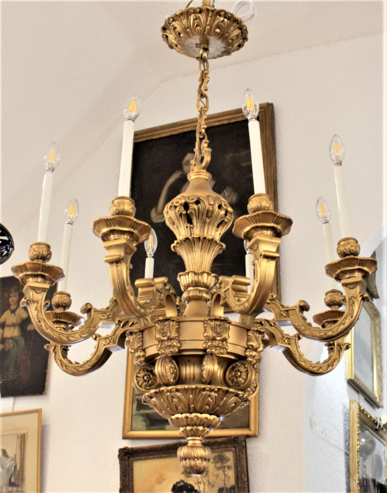 This very large and substantial cast and gilt bronze eight-arm chandelier was made in France in approximately 1900 in the Louis XIV style. The ornate and very heavy casting is decorated with stylized leaves and scrollwork from the original ceiling