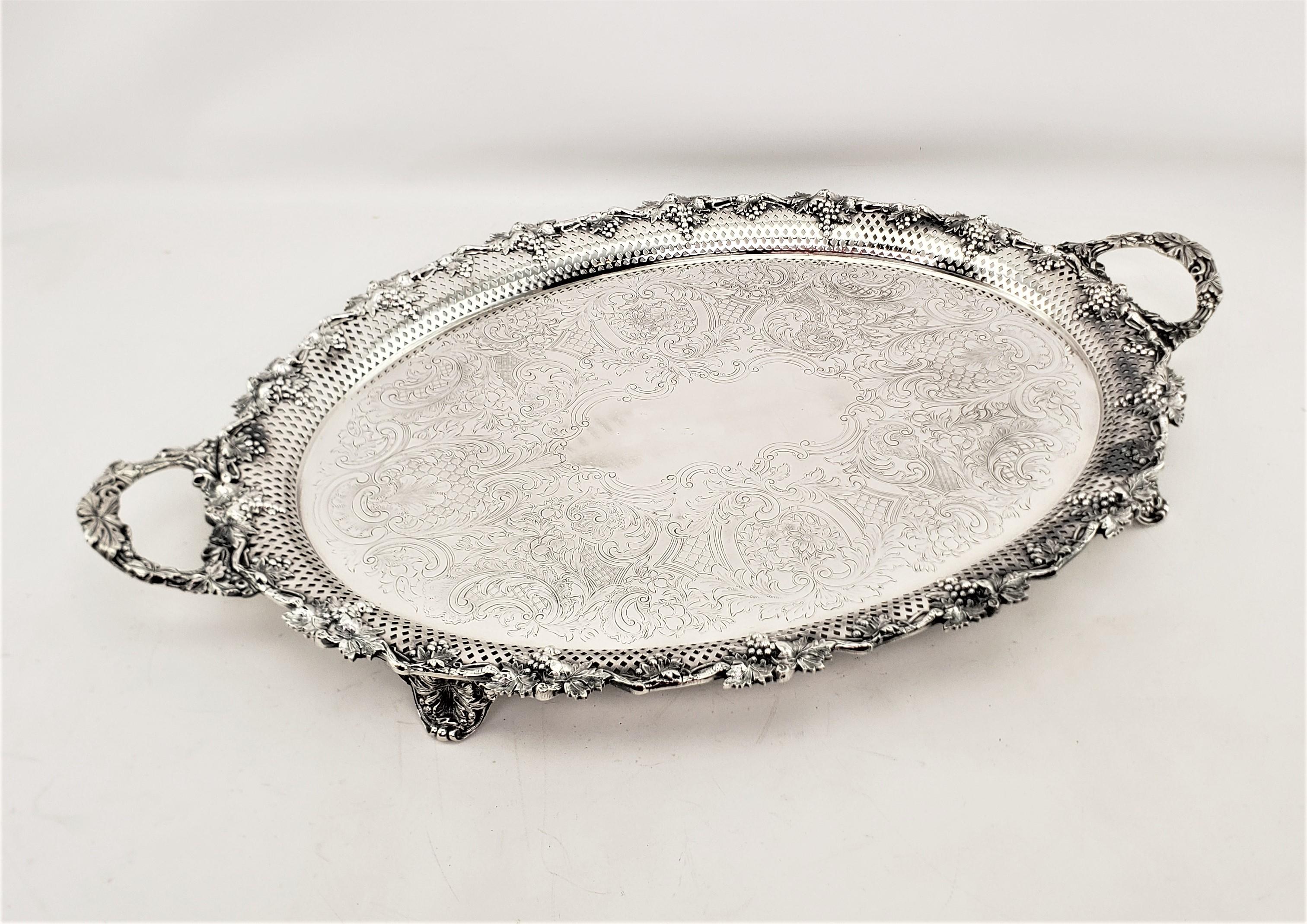 This large silver plated oval tray is unsigned, but presumed to have originated from England and date to approximately 1920 and done in a Victorian style. The tray is decorated with bold grape and leaves around the rim, which is accented by the