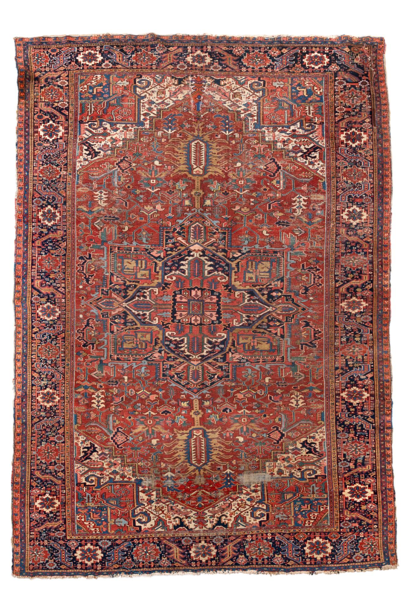 A grand-scale antique Heriz rug, woven circa 1910–1920 in Northwest Persia, featuring a monumental central medallion flanked by dramatic geometric spandrels and a richly detailed field. This piece captures the bold essence of Heriz village weaving —