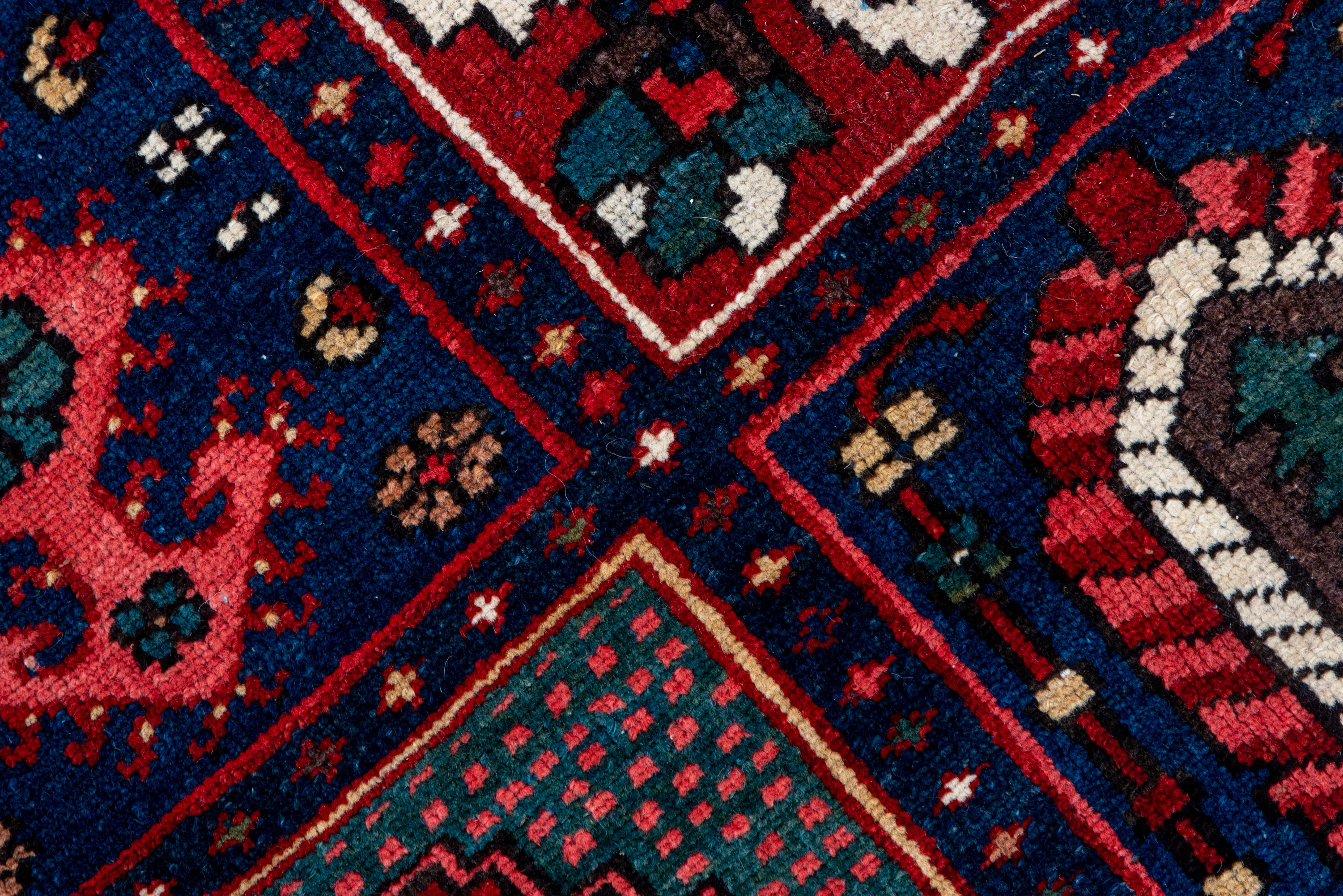 A nine by twelve windowpane garden design classic Baktiari Rug, with weeping willows, mihrabs, botehs, cypresses, mini-rugs and radiating floret arrays, on straw, cream, red, green and various blue grounds. Ecru border with reversing palmettes,