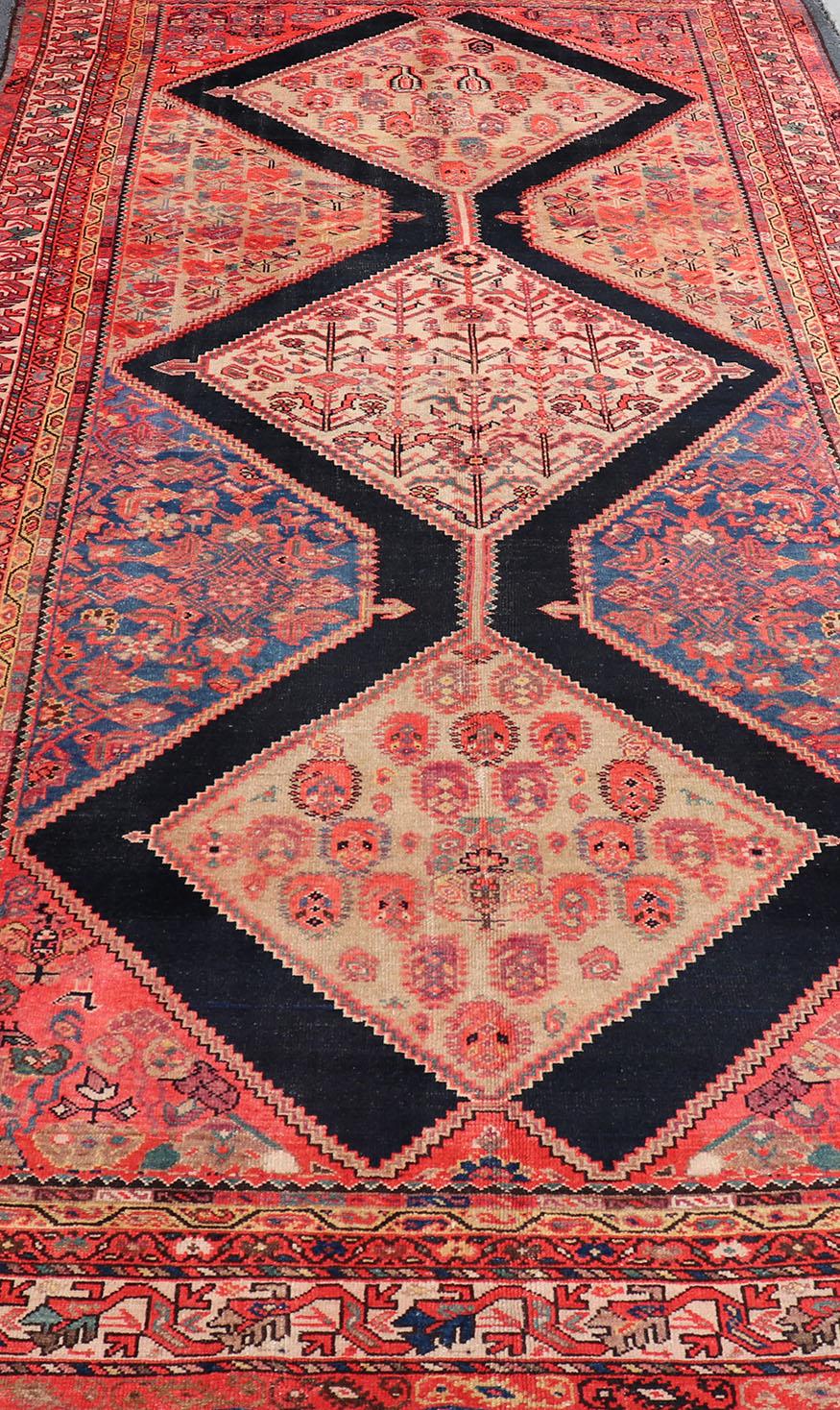 Dieser mehrfarbige, antike persische Malayer-Galerie-Läufer zeichnet sich durch ein geometrisches Medaillon-Muster aus, das mit subgeometrischen Motiven verziert ist. Das gesamte Stück ist von einem komplementären, mehrstufigen Rahmen umgeben.