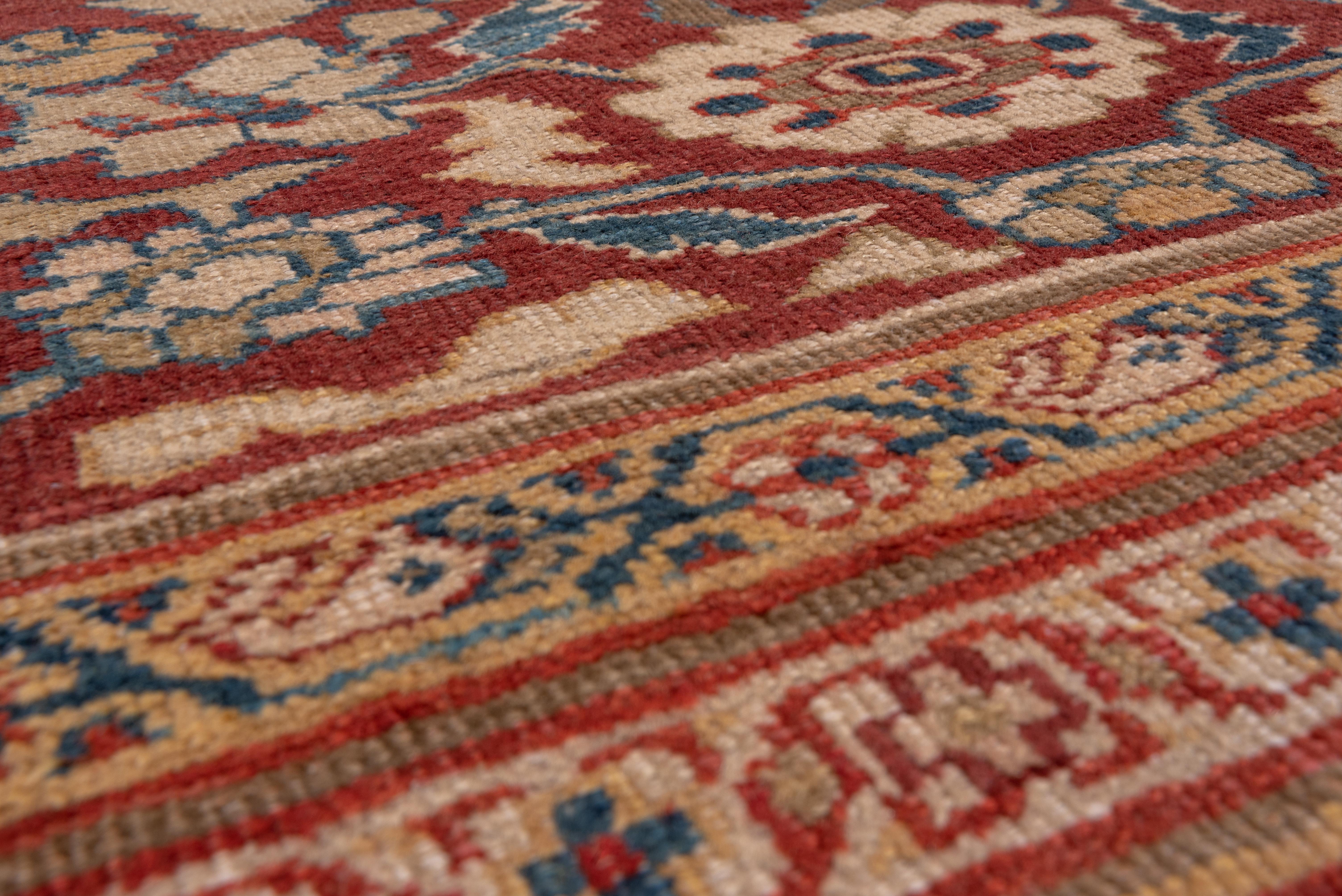A magnificent carpet with a shaped off white field with a lightly lobed red medallion enclosing bottehs and red/blue corner pieces. Petal palmettes and lancet leaves and pendants accent the field and a broad dark red border with a complex pattern of